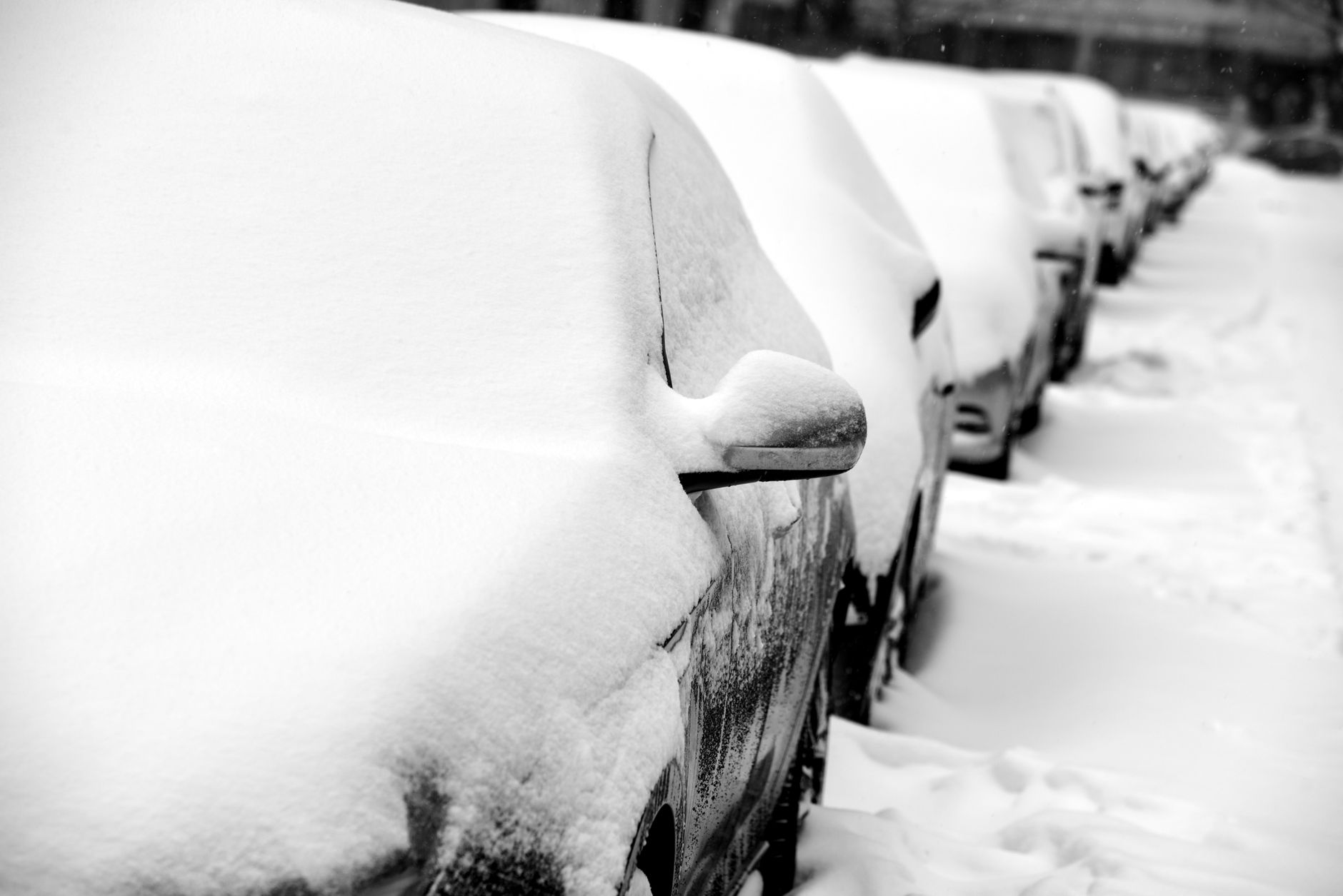 A row of cars buried in snow