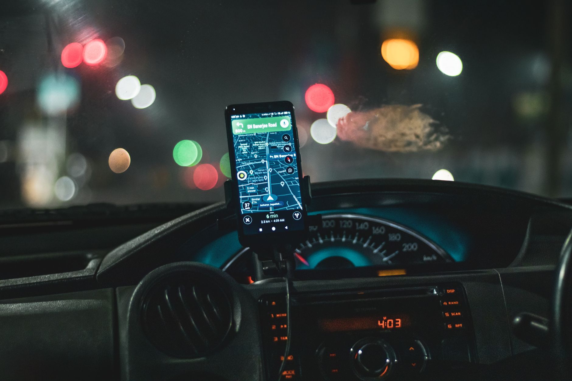 A phone showing a map in a dashboard mount at night
