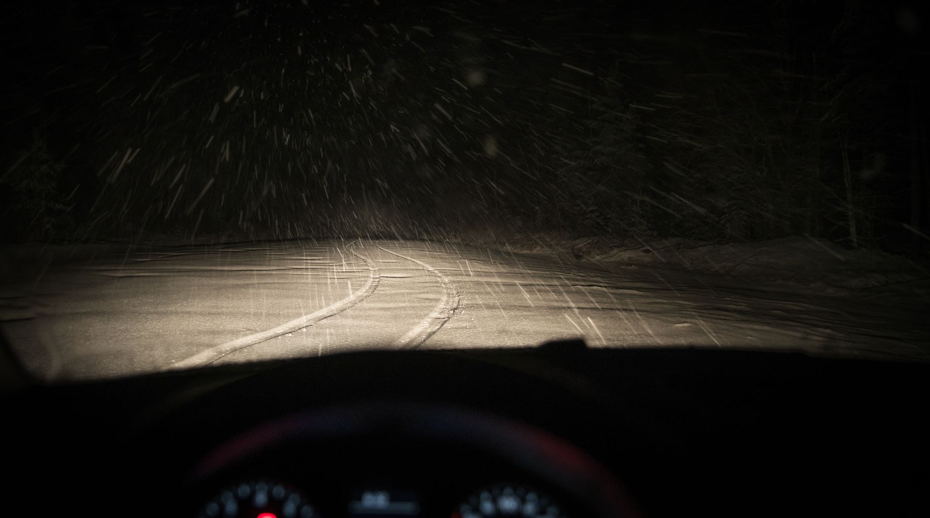Headlights on a snowy road at night
