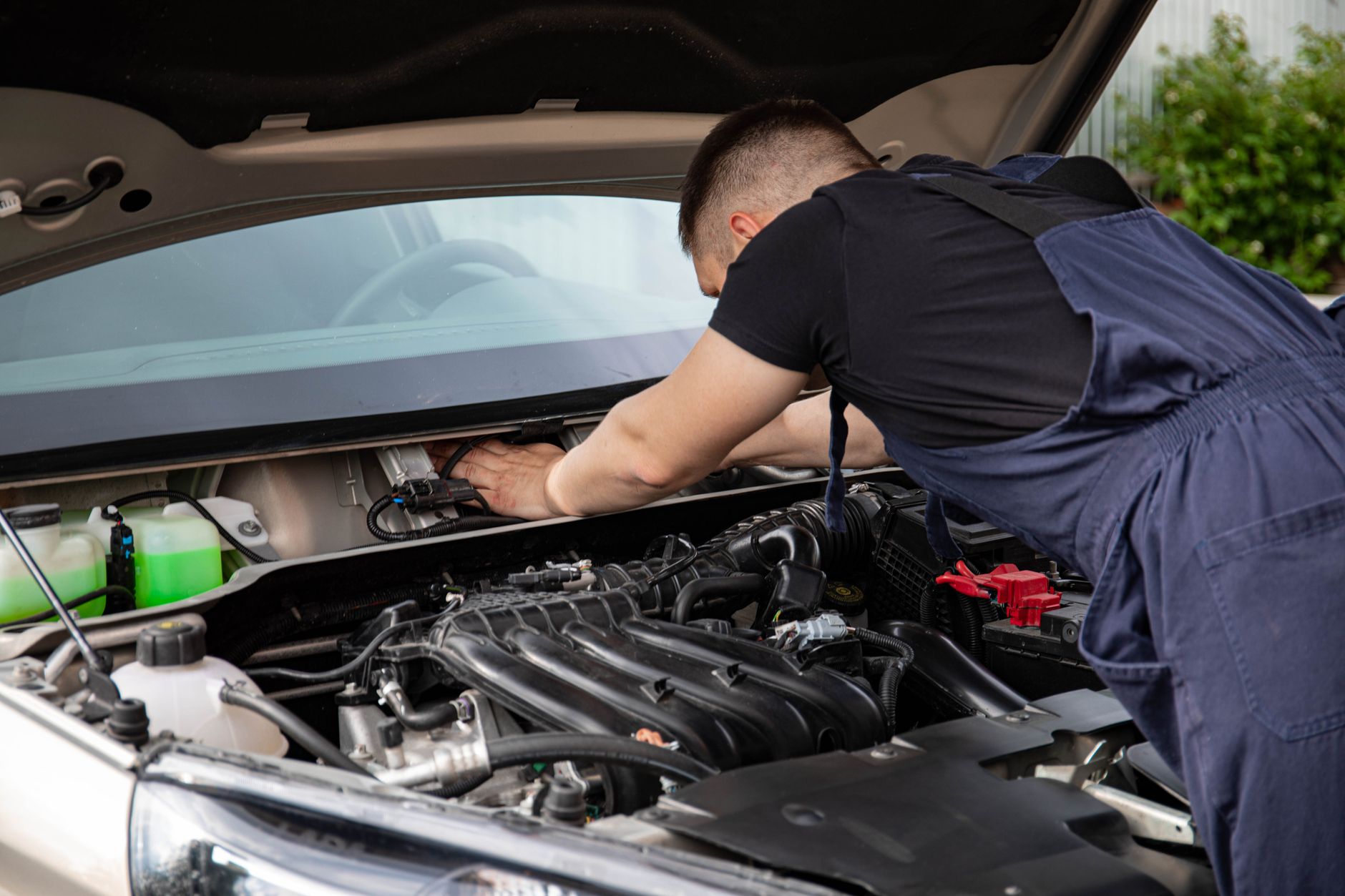 A mechanic leaning over an open engine bay
