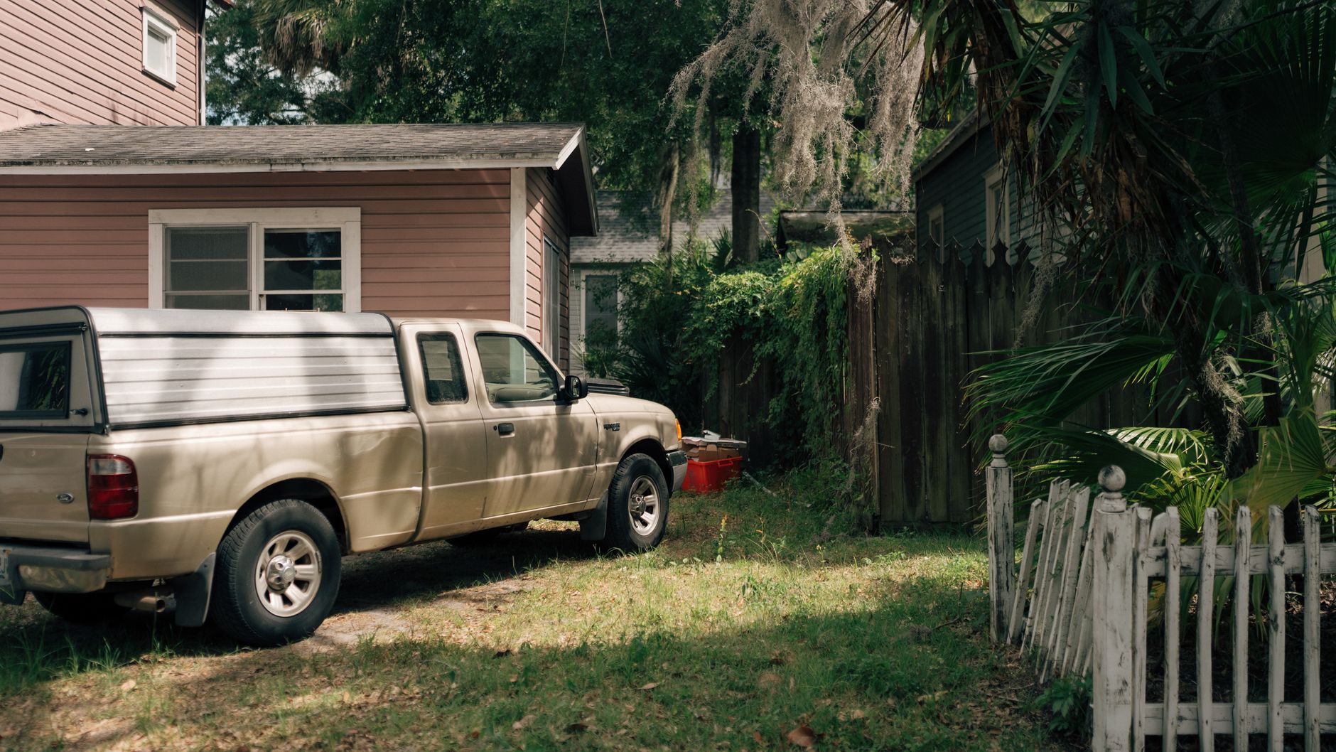 A pickup truck parked beside a house