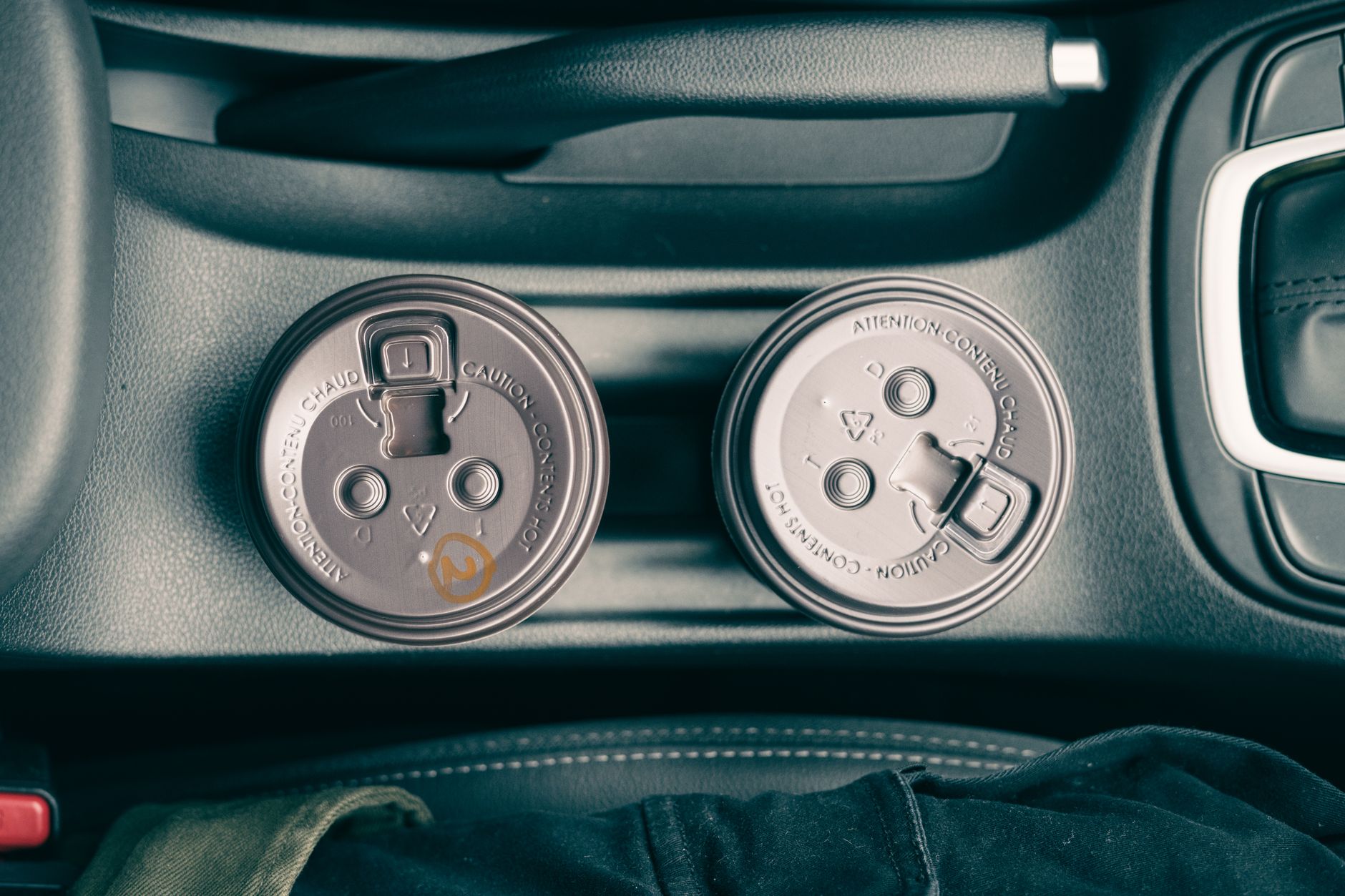 Two coffee cups in a car cup holder