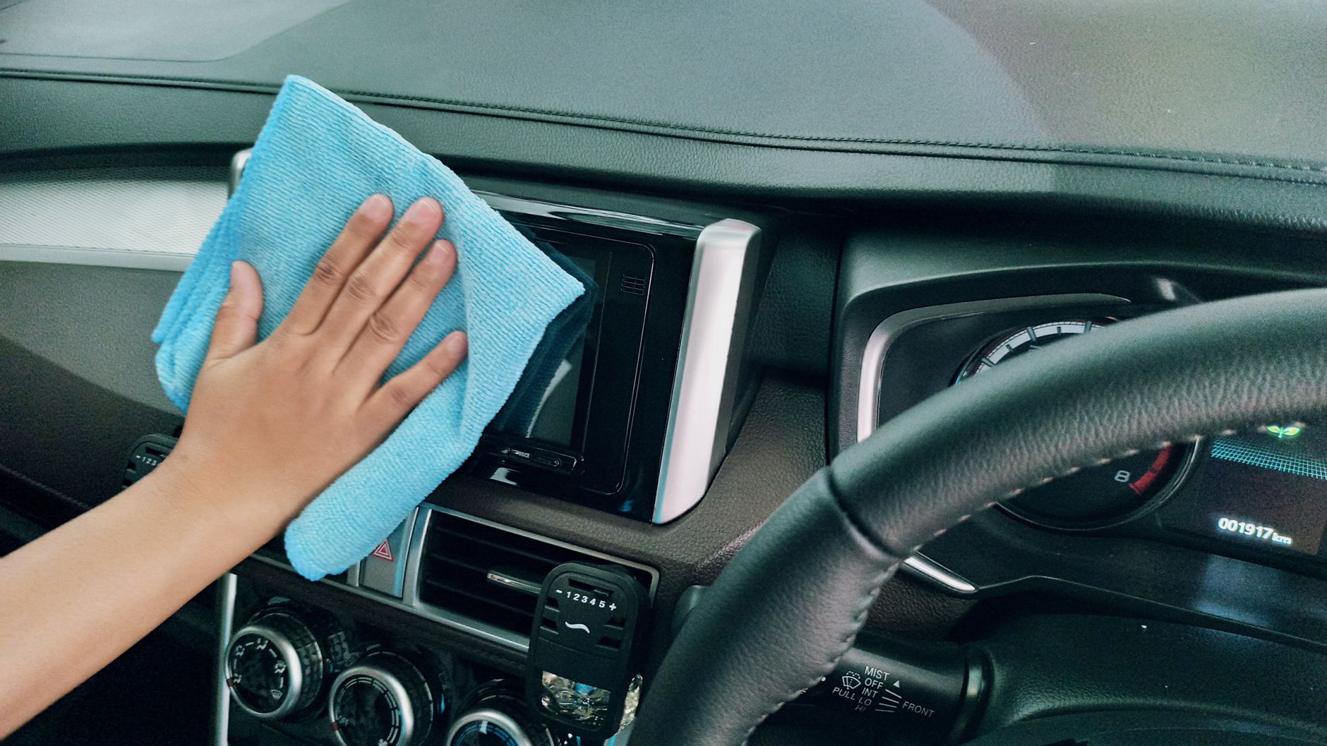 Wiping a car panel with a microfiber cloth