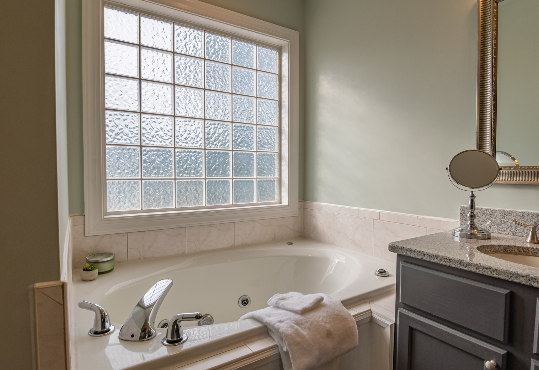 Best caulk gun: a jetted tub and vanity in a bright bathroom