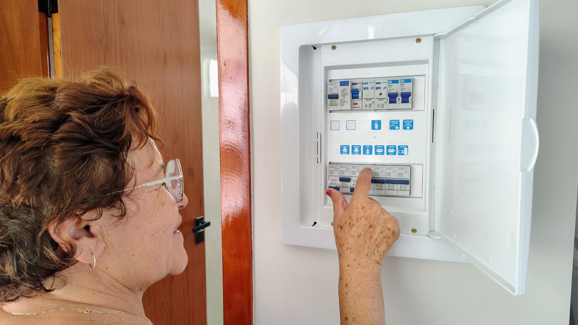 A woman checking a breaker panel