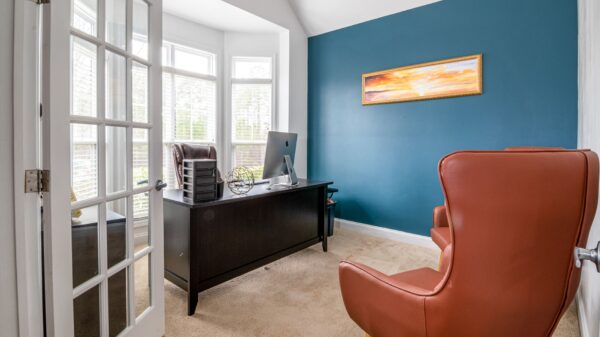Best chair mat: a desk and leather chair in a carpeted home office