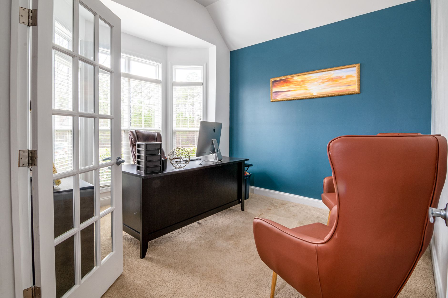 Best chair mat: a desk and leather chair in a carpeted home office