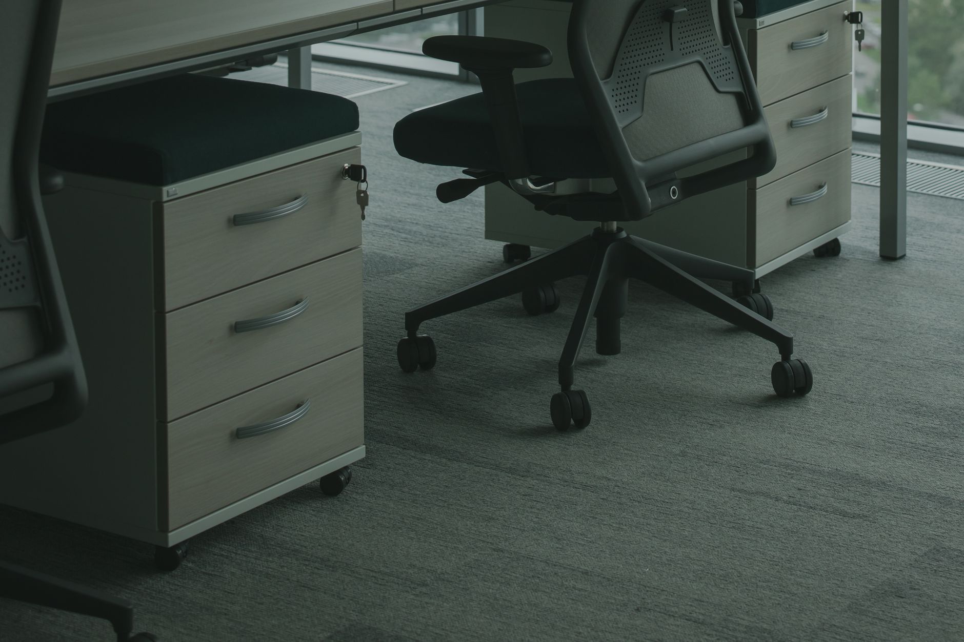 Rolling office chairs and drawer units on carpet