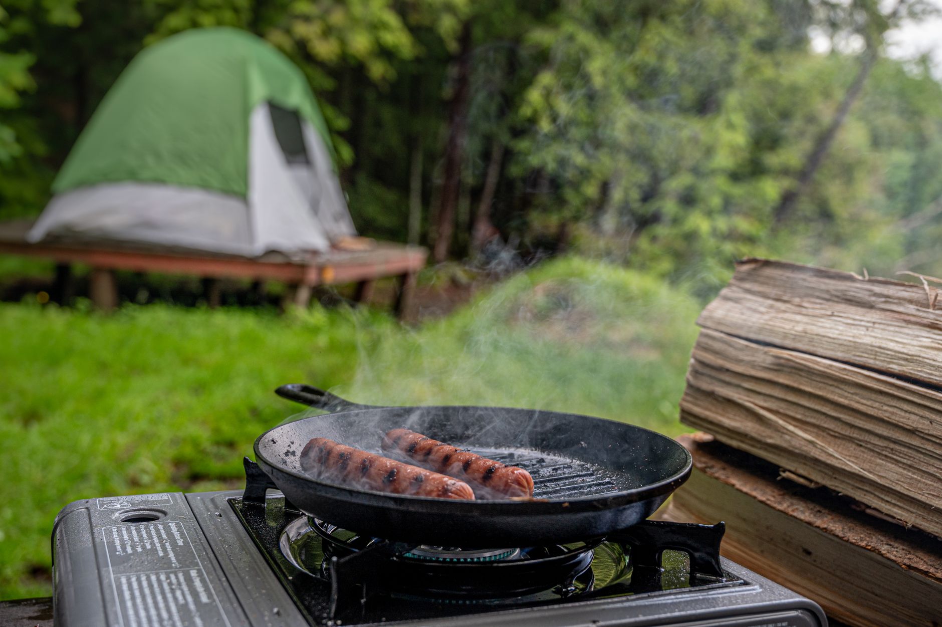 Sausages in a pan on a portable camp stove