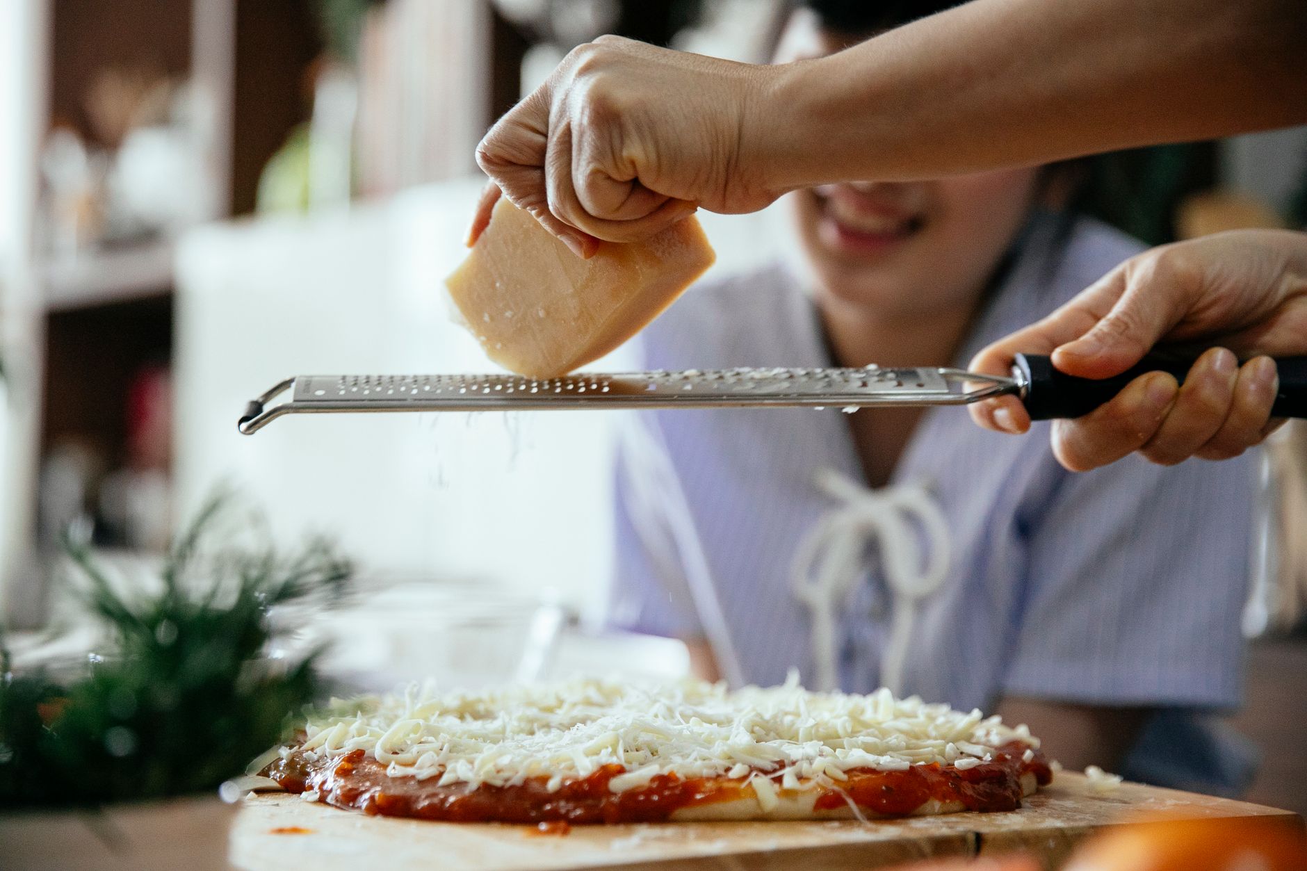Best cheese grater: freshly grated cheese in a home kitchen