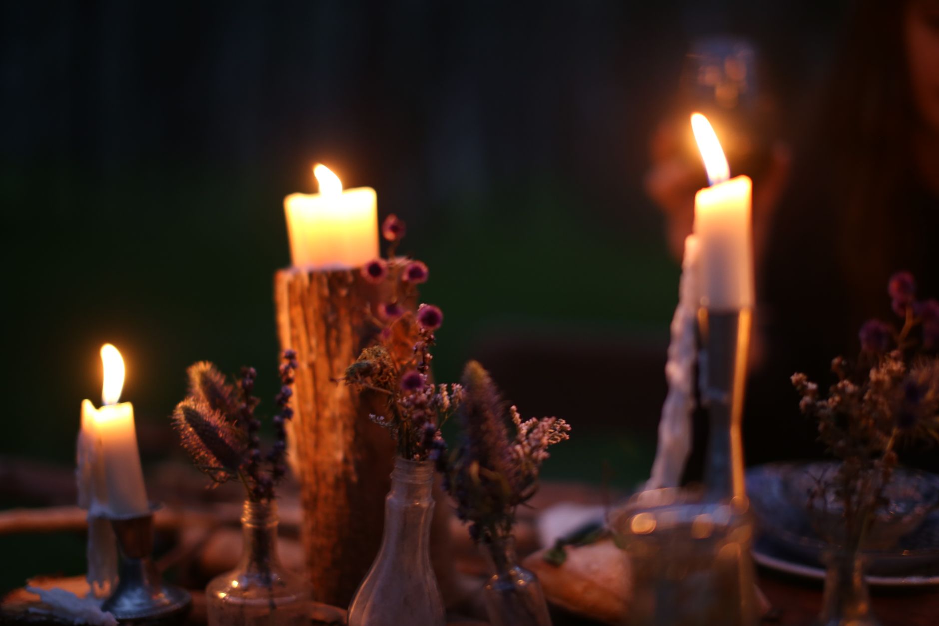 An outdoor table set for dinner with candles