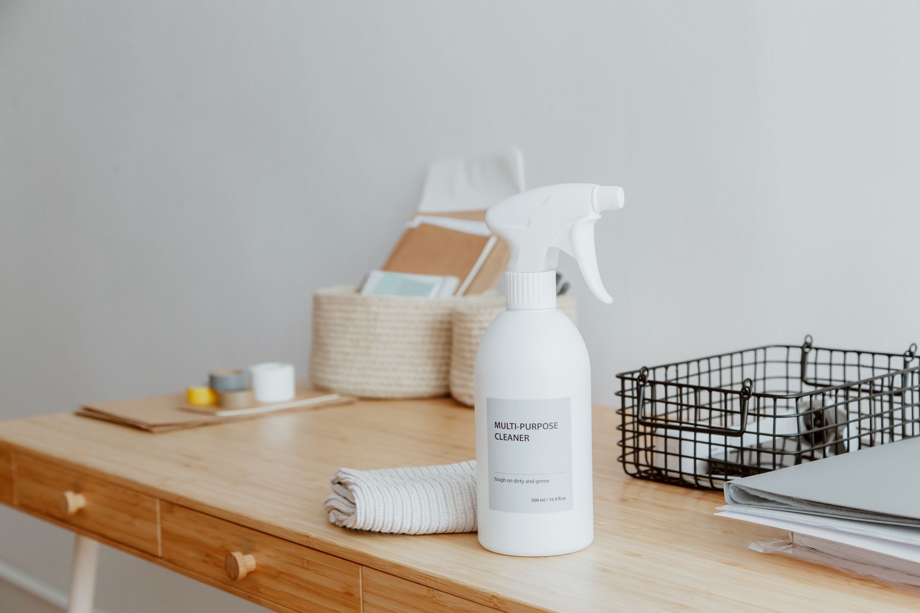 Best cleaning caddy: a spray bottle and baskets on a wooden desk