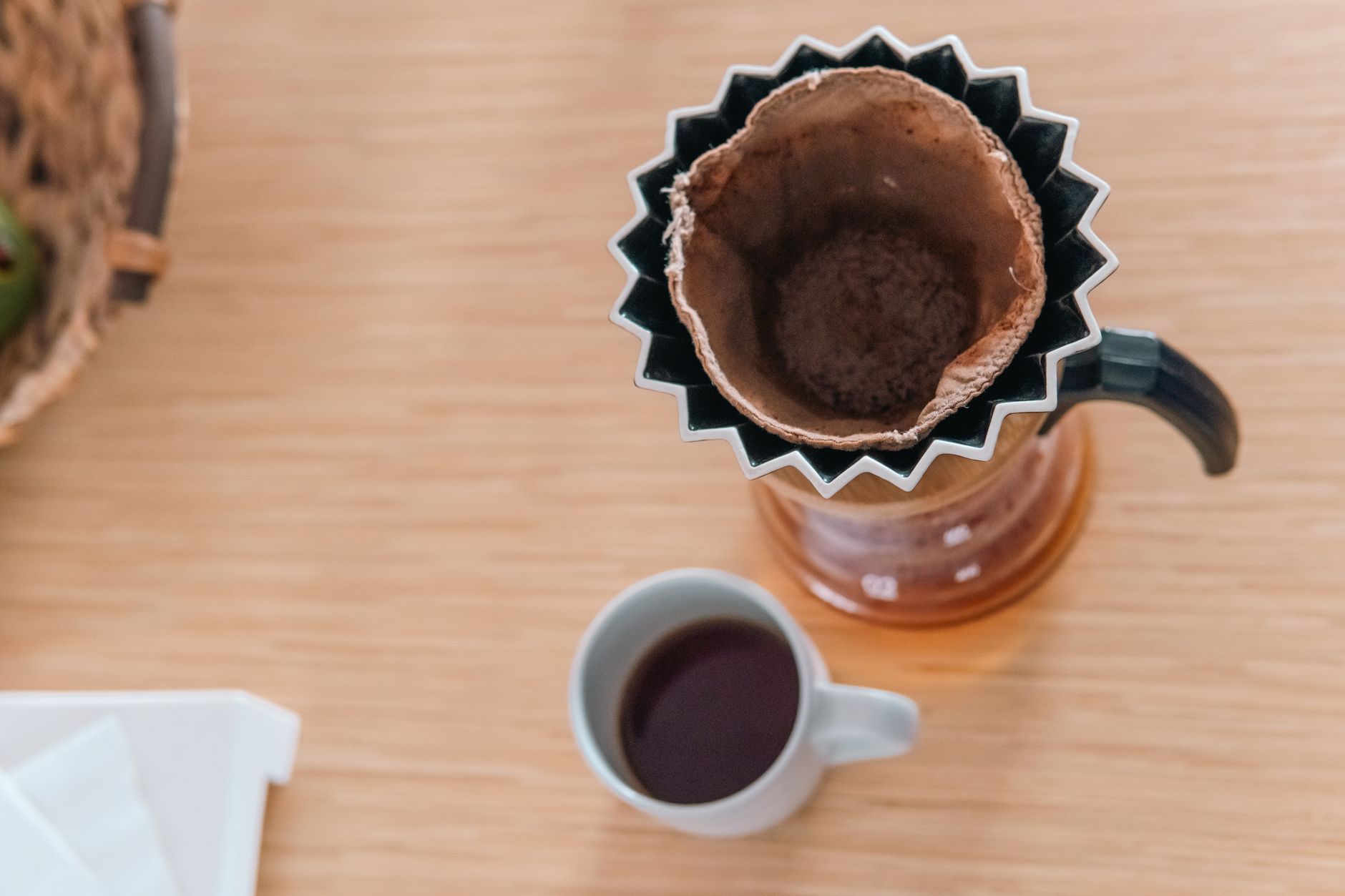 Pour-over brewer with medium-ground coffee and a cup