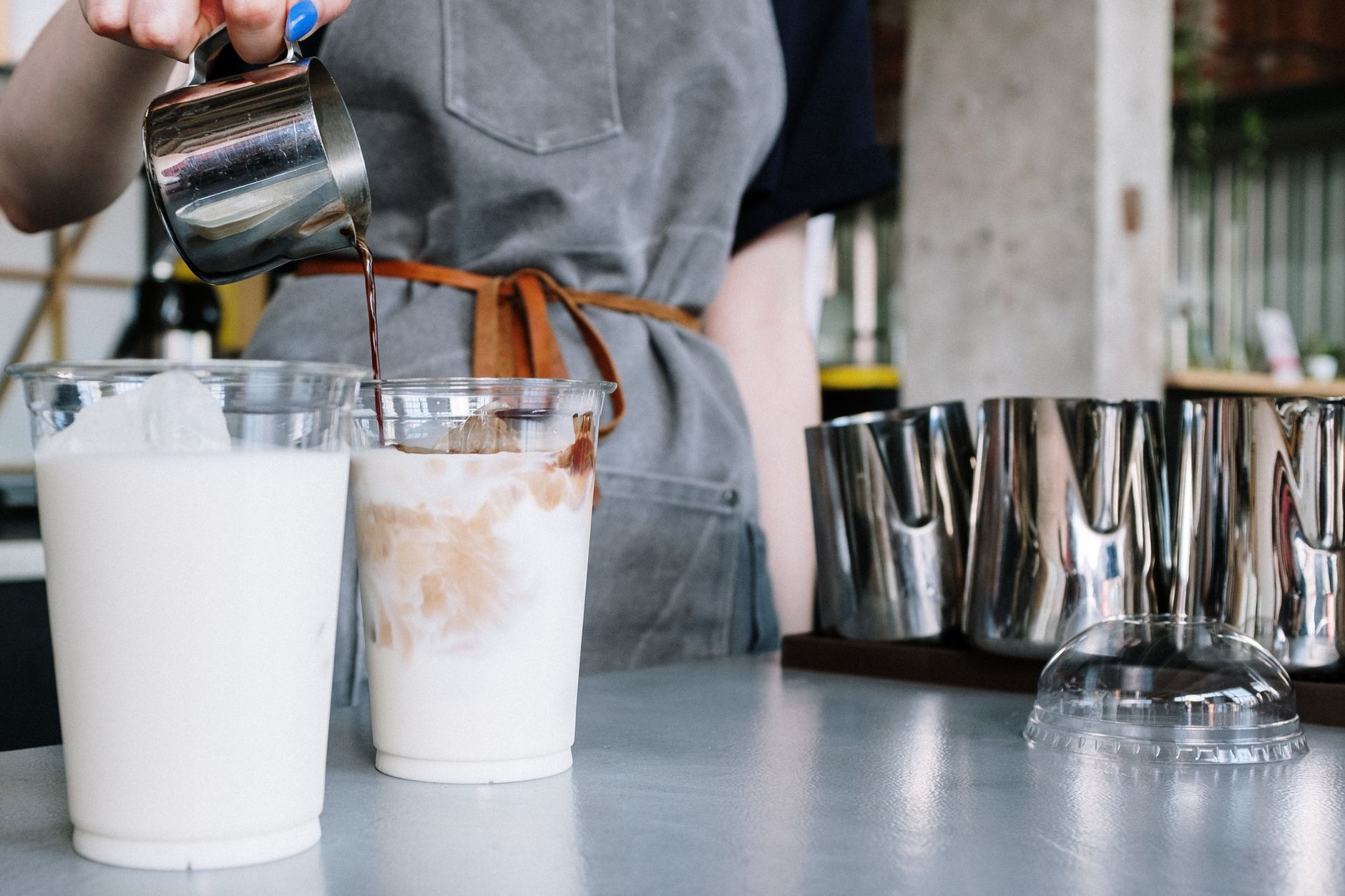 Coffee poured over milk in to-go cups