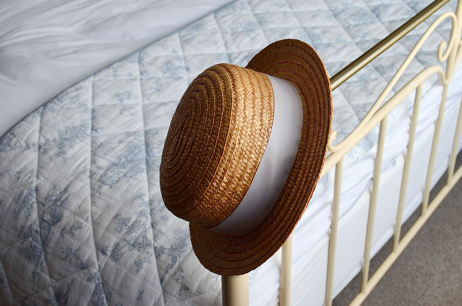 A straw hat on a bed frame