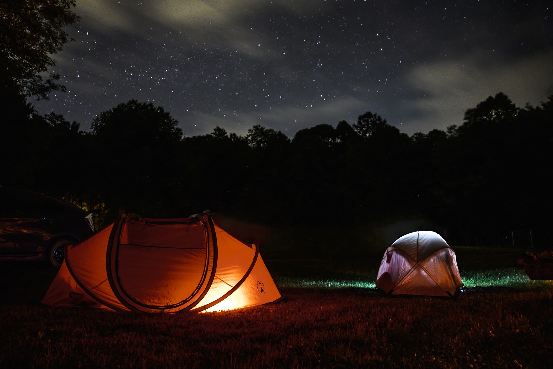 Glowing tents under a starry sky