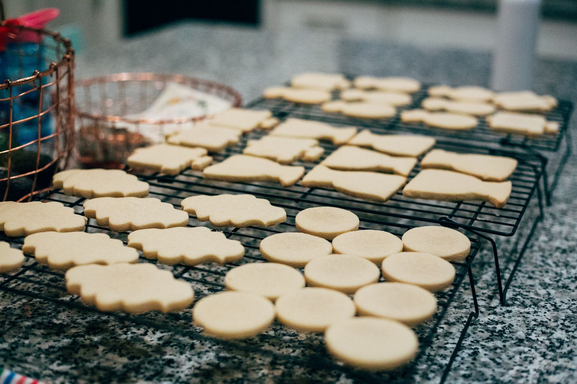 Sugar cookies cooling on stacked wire racks