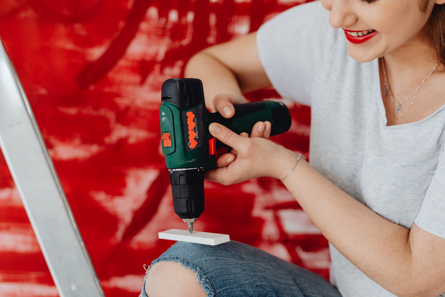 A woman using a cordless drill