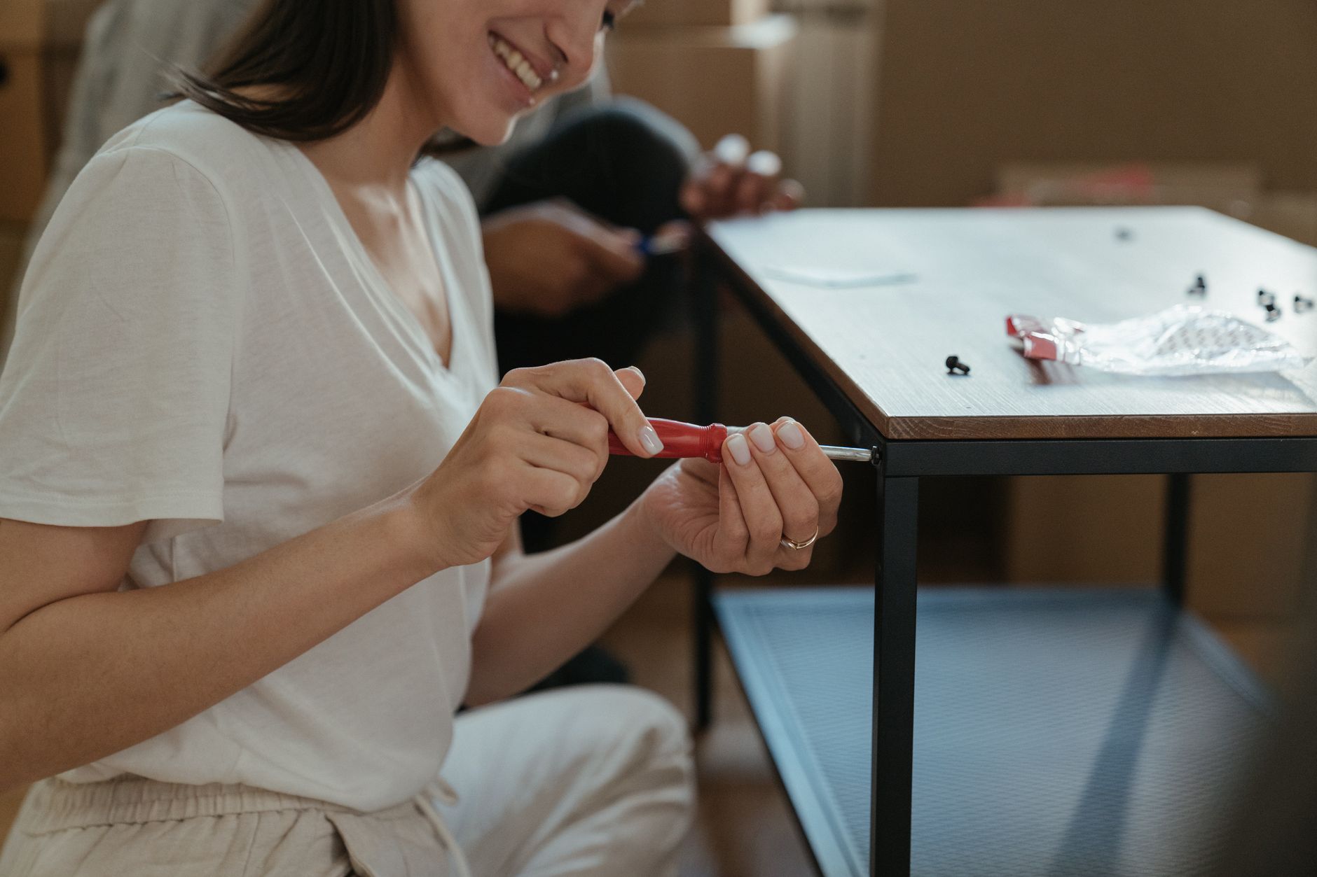 A woman assembling furniture with a screwdriver