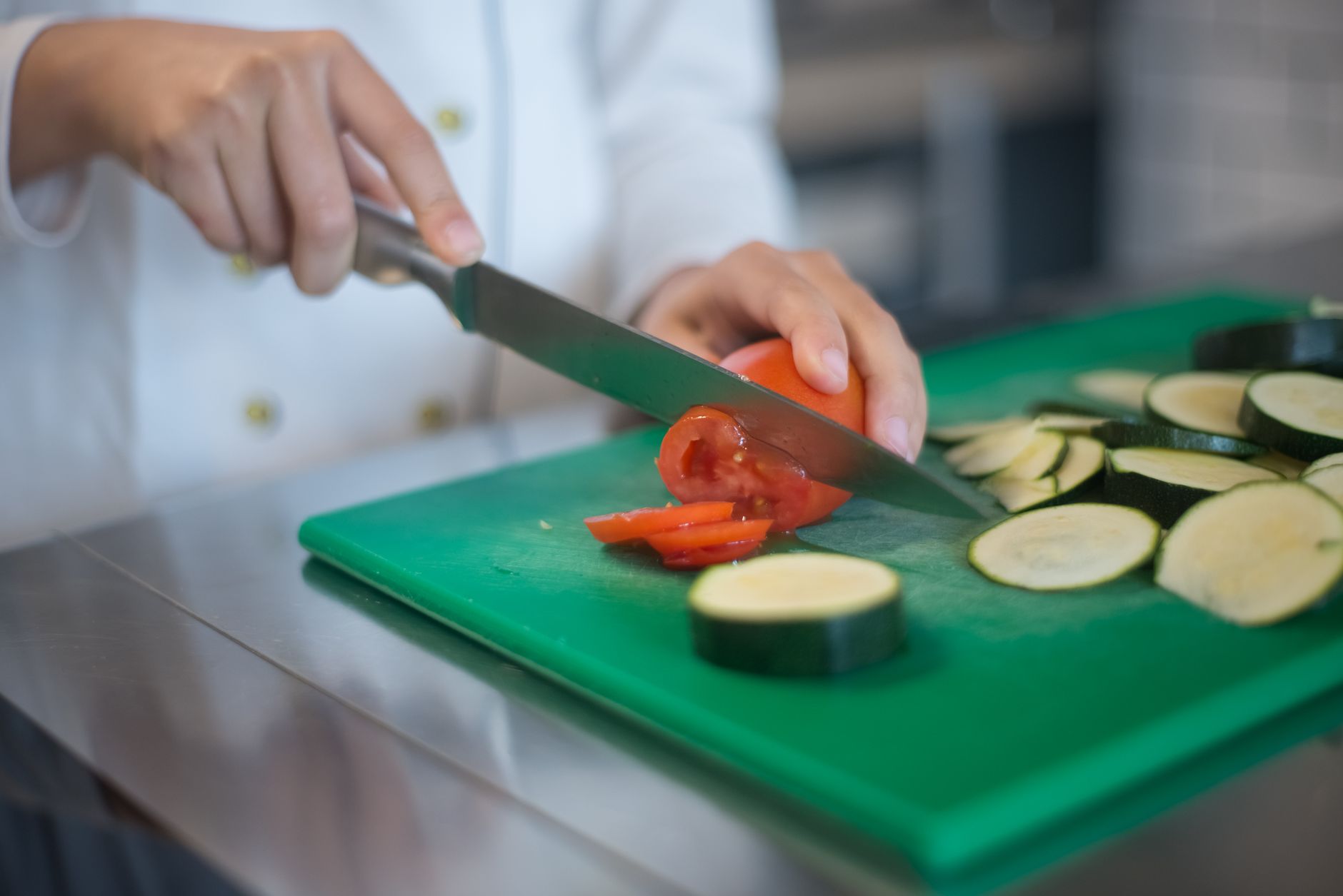 Slicing zucchini on a green cutting board