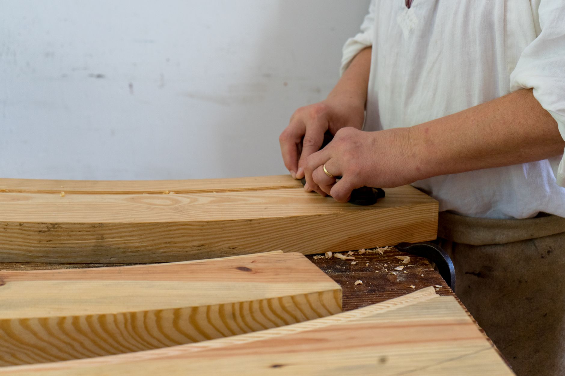 A woodworker shaping a plank