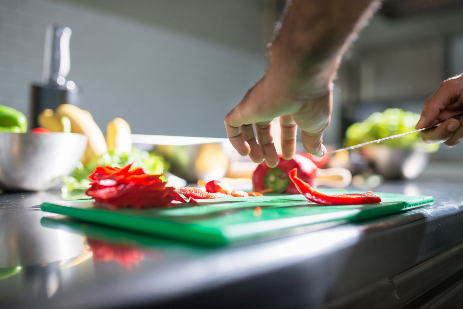 Slicing peppers on a green cutting board
