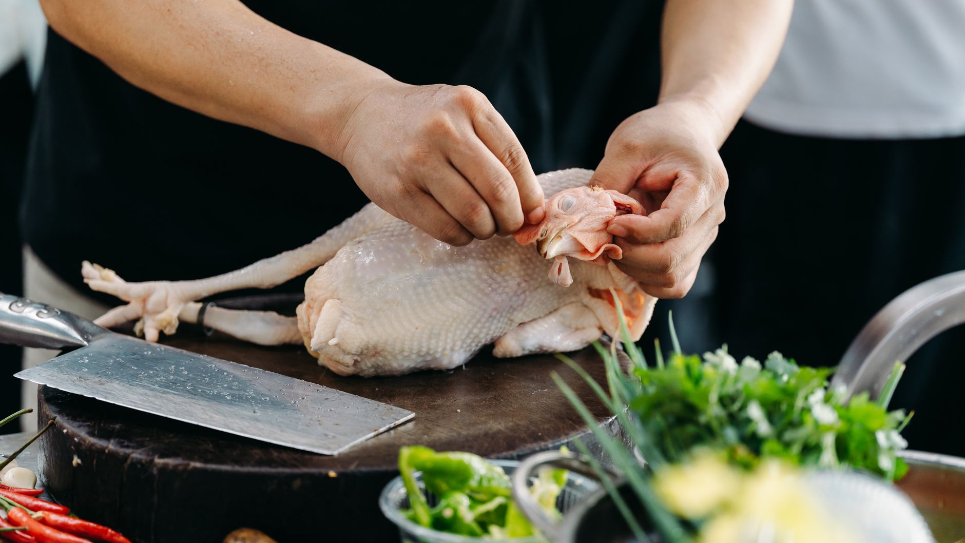 Preparing a raw chicken on a dark board