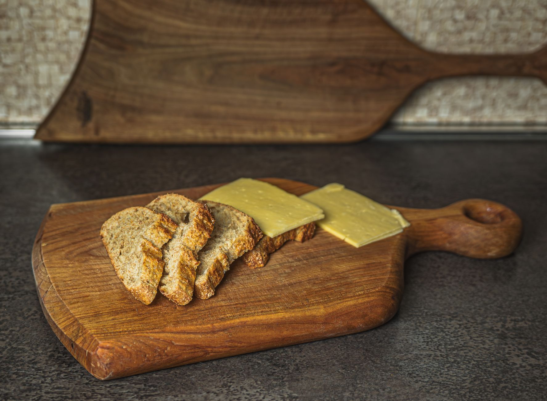 Bread and cheese on a wooden paddle board