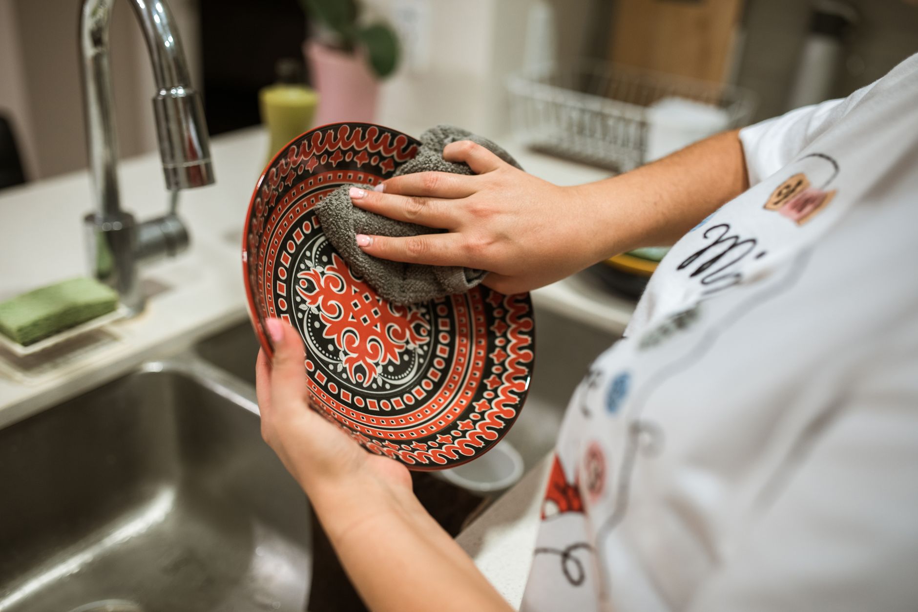 Washing a plate at a kitchen sink
