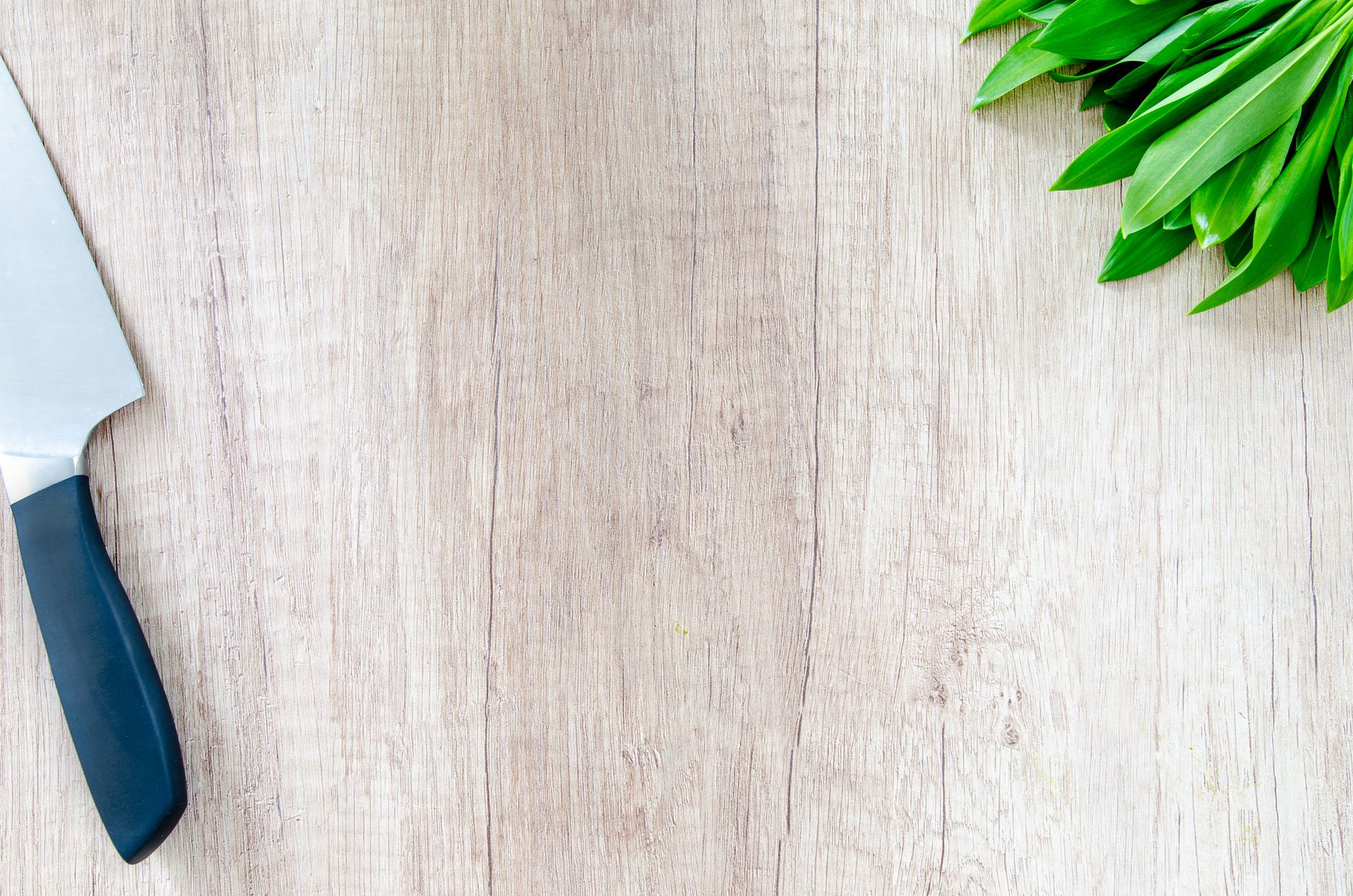 A knife beside a light wood surface