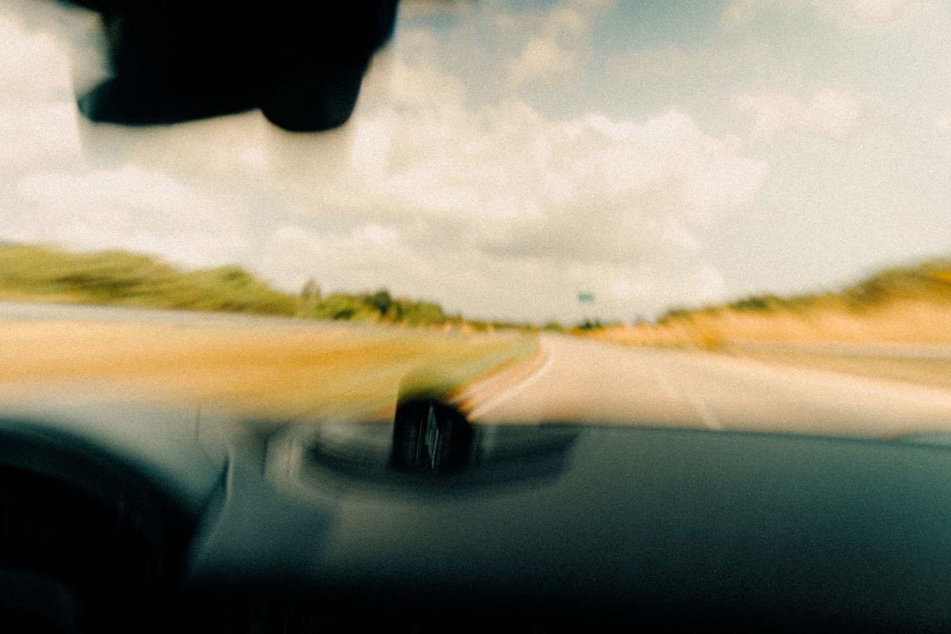 A blurred road seen through a windshield
