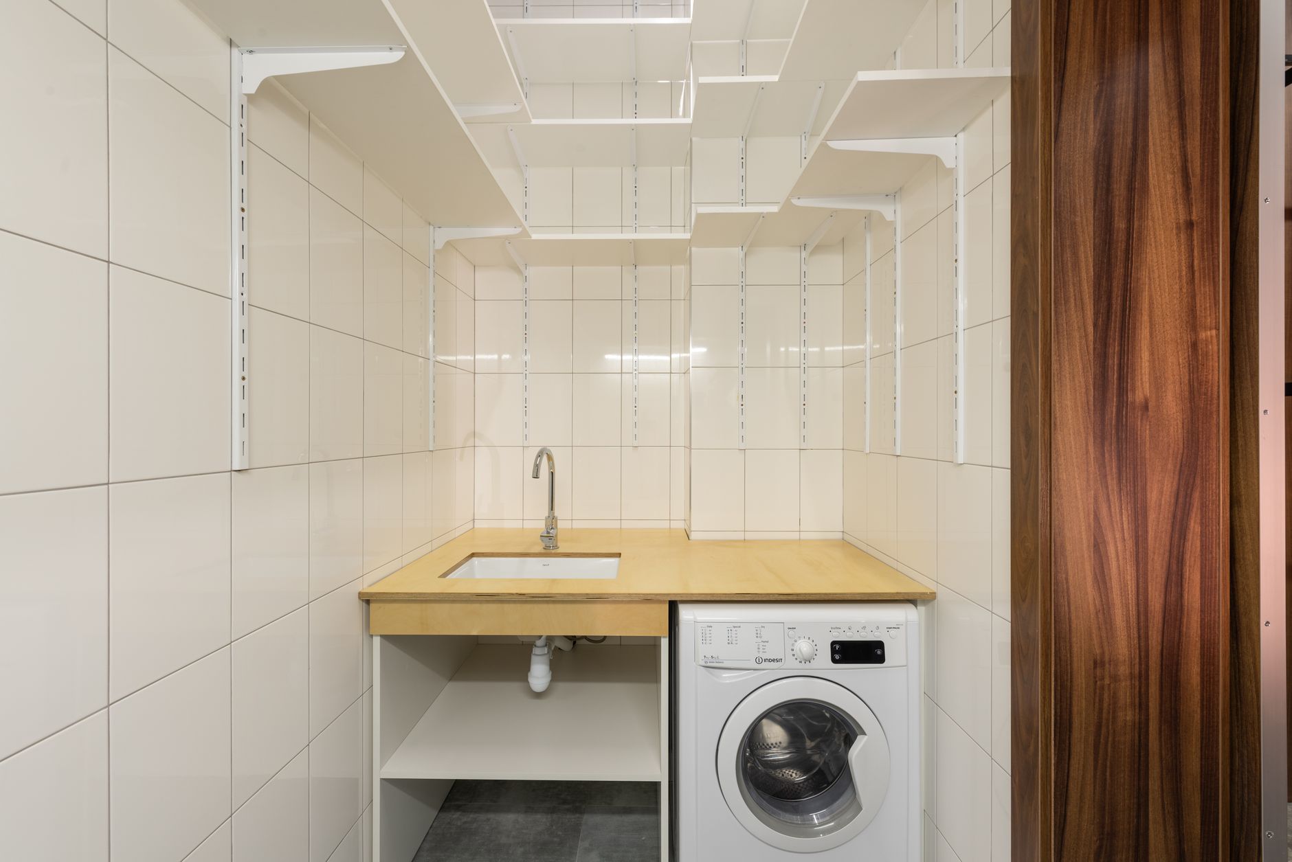 A small laundry room with a sink and washer