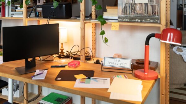 Best desk lamp: a red desk lamp beside a monitor on a wood desk