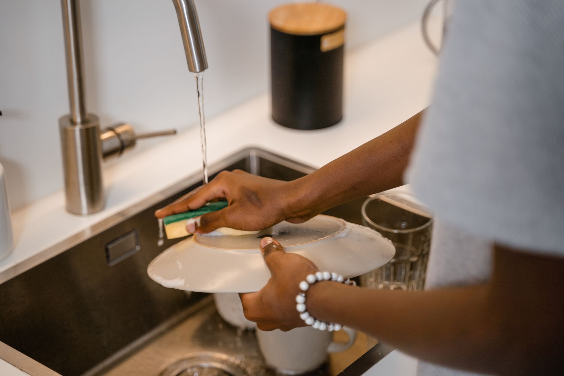 Washing a plate under a running tap