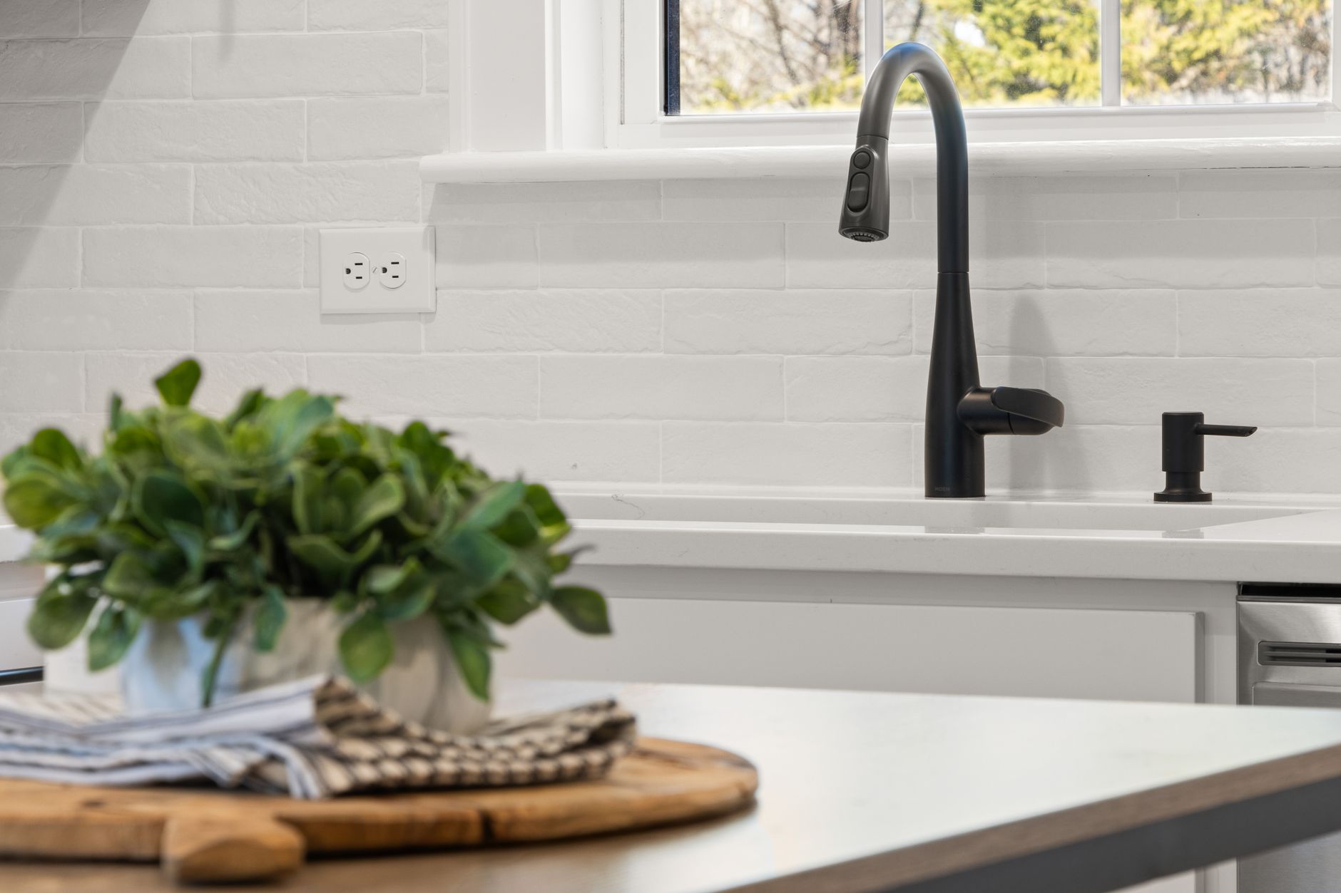 A kitchen sink with a black faucet