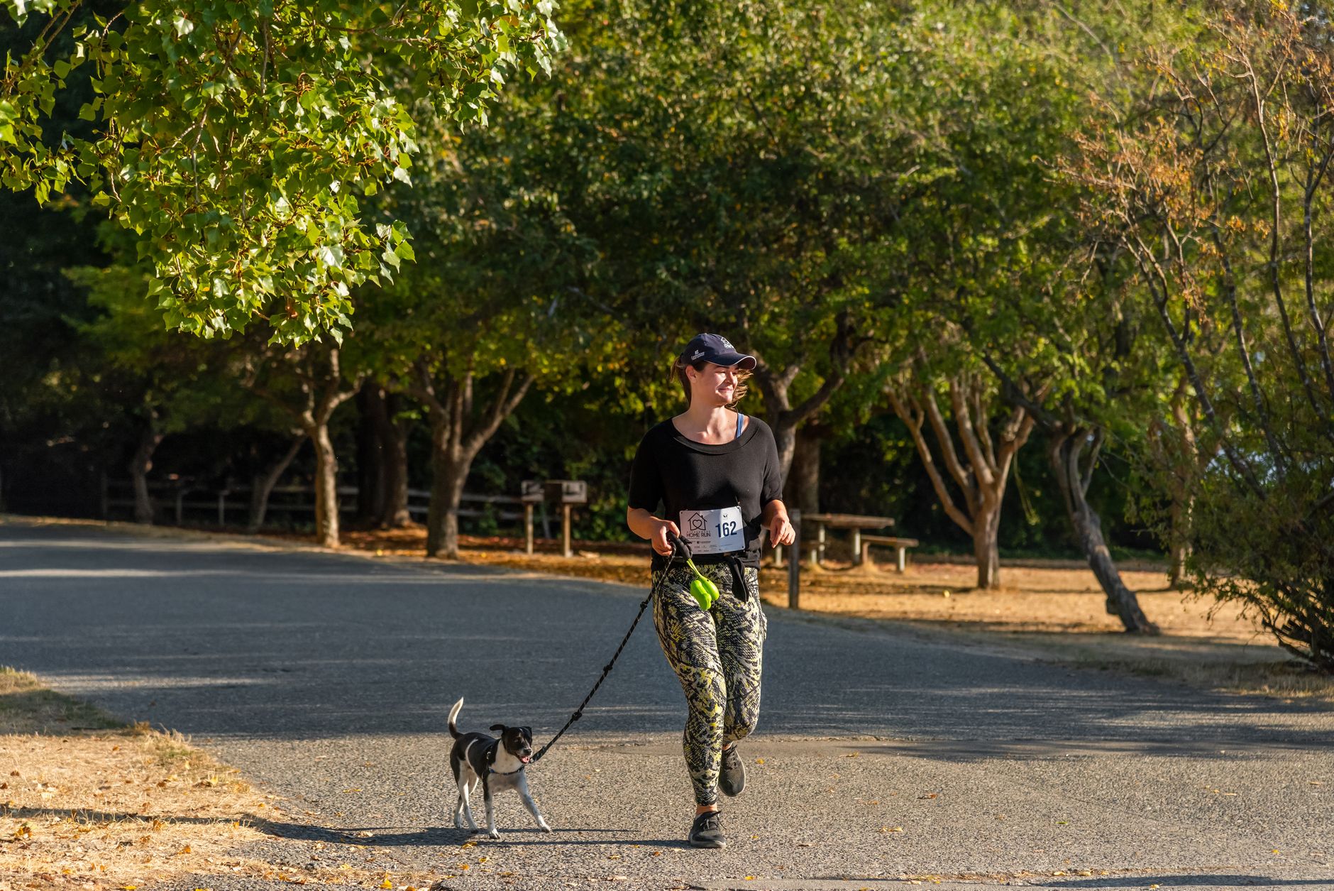 A woman jogging with a small dog