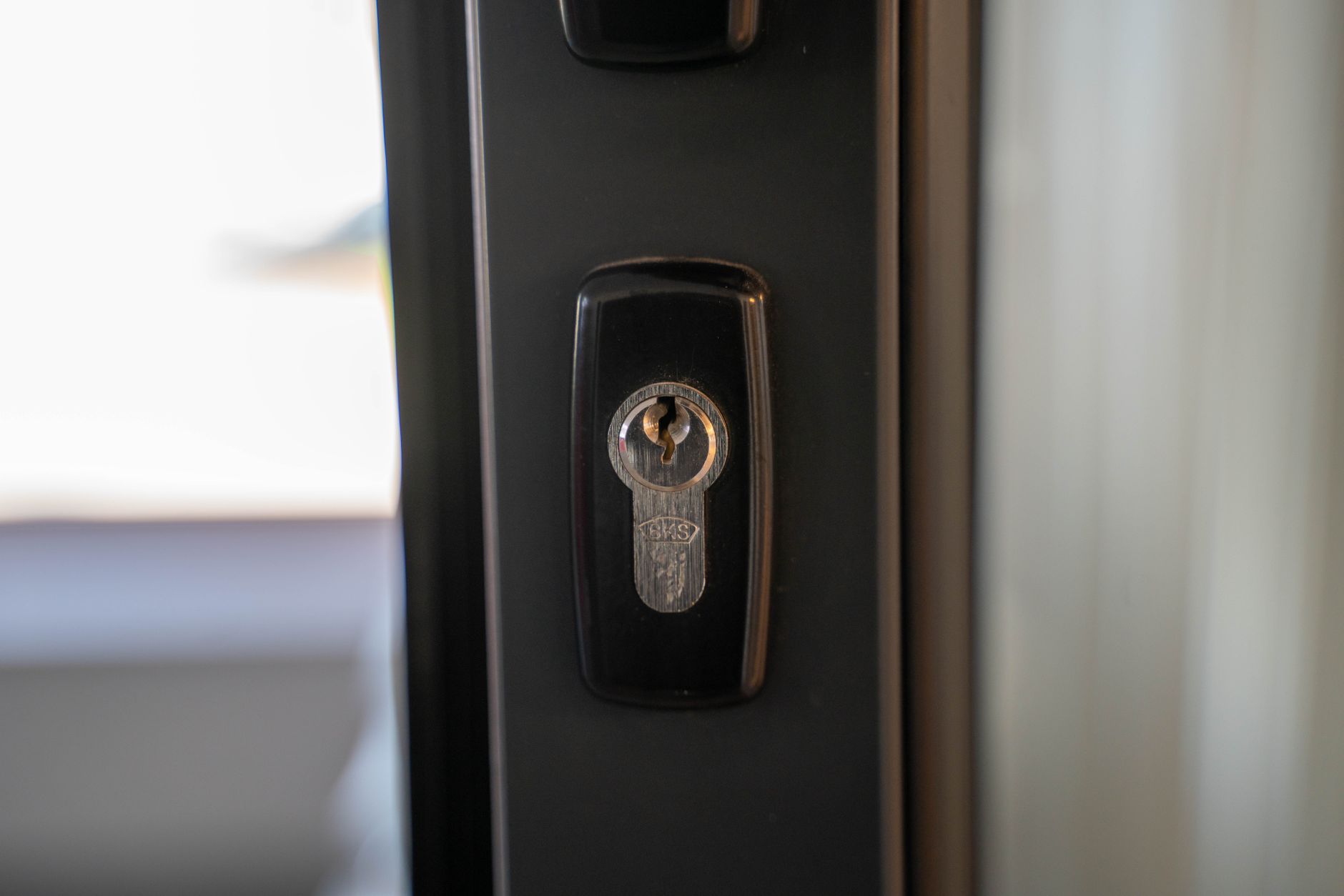 A cylinder lock on a dark door frame