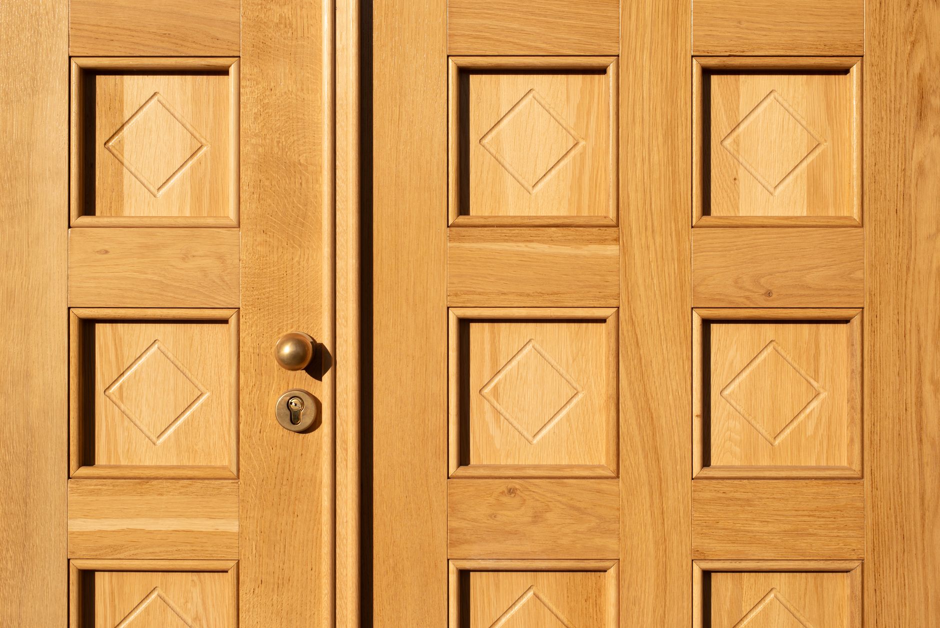 A wooden double door with a knob and lock