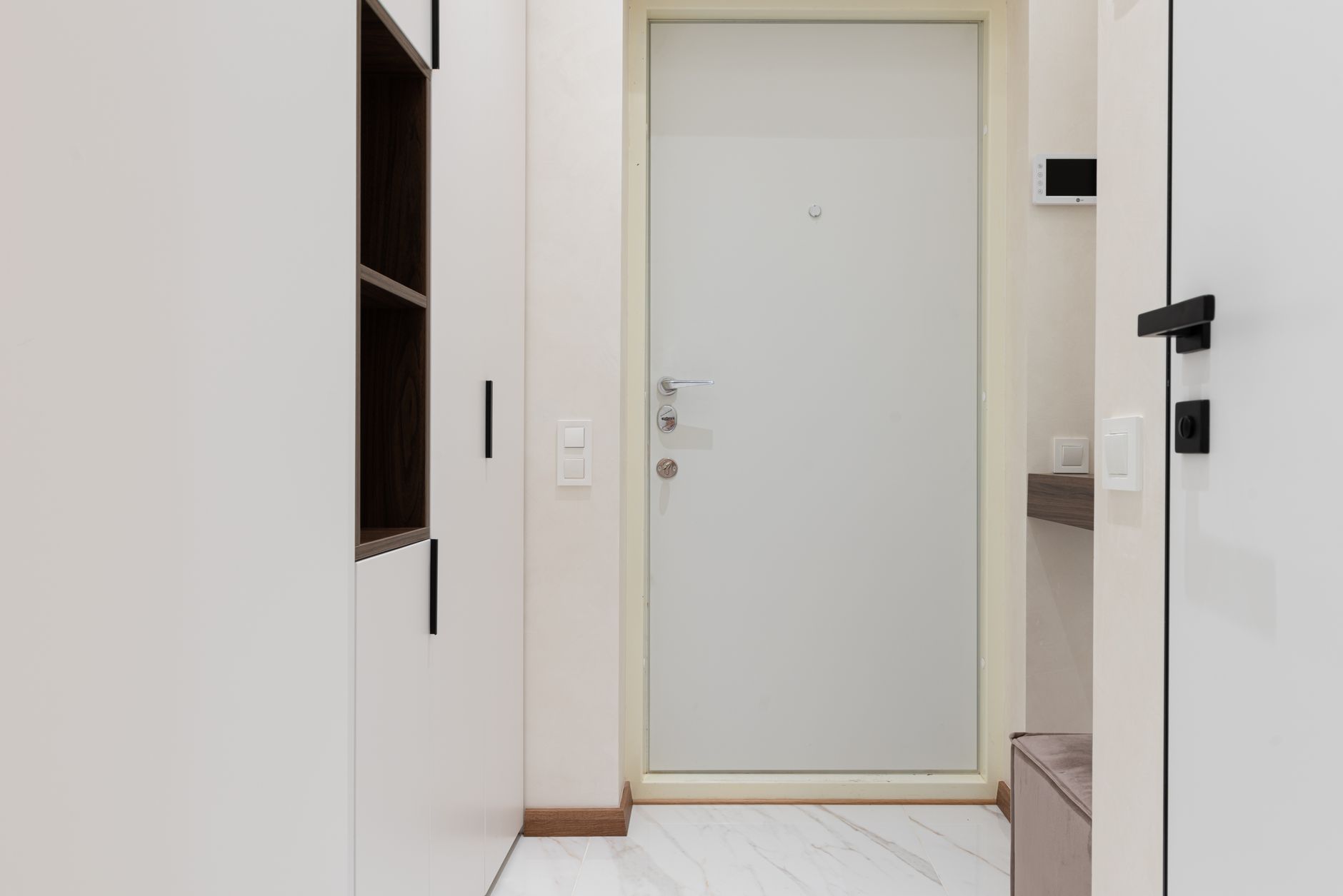 A white apartment entry door in a bright hallway