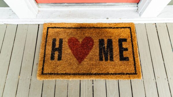 A coir doormat with a heart design on a porch