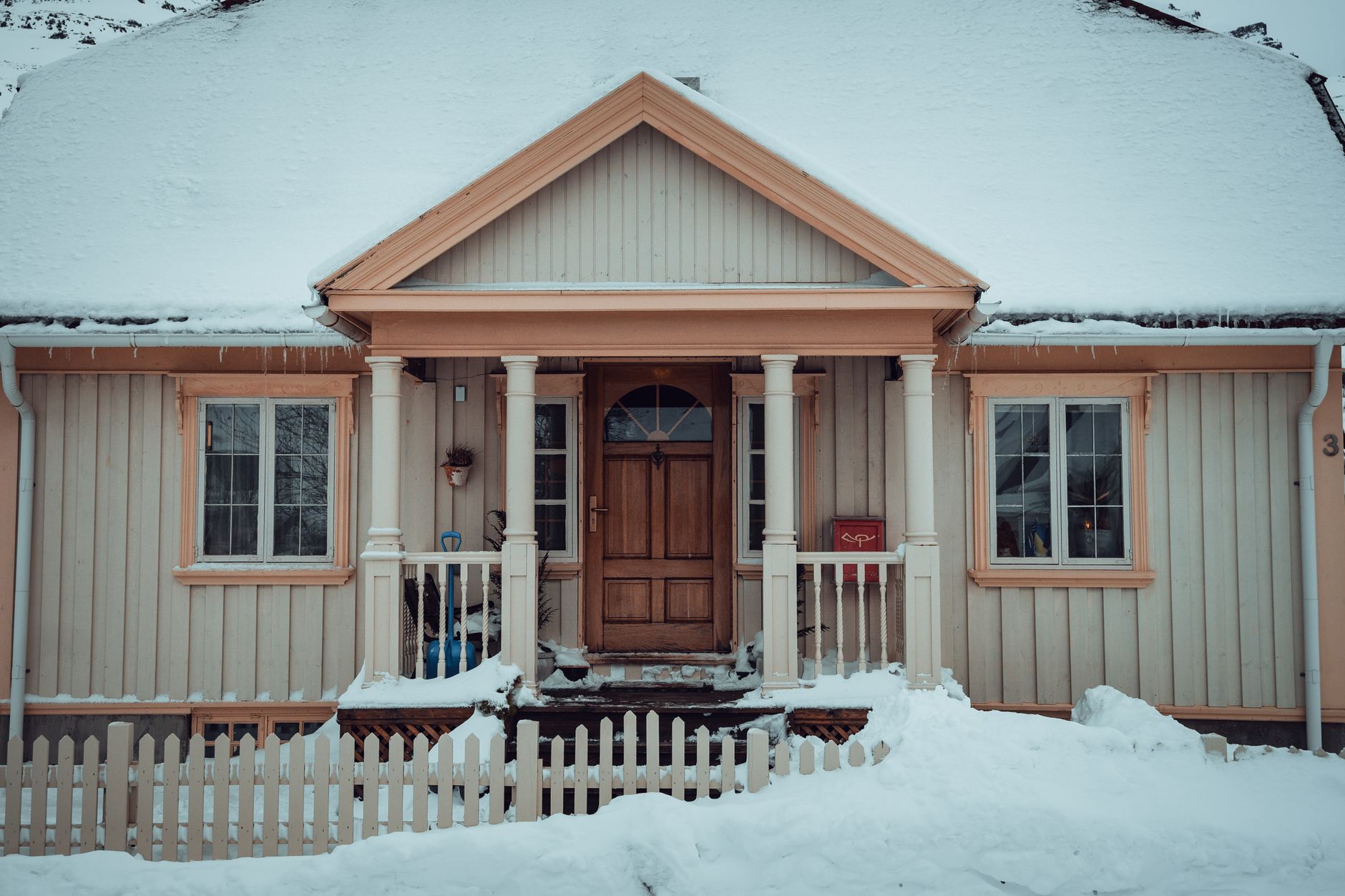 A house with snowy front steps and a porch