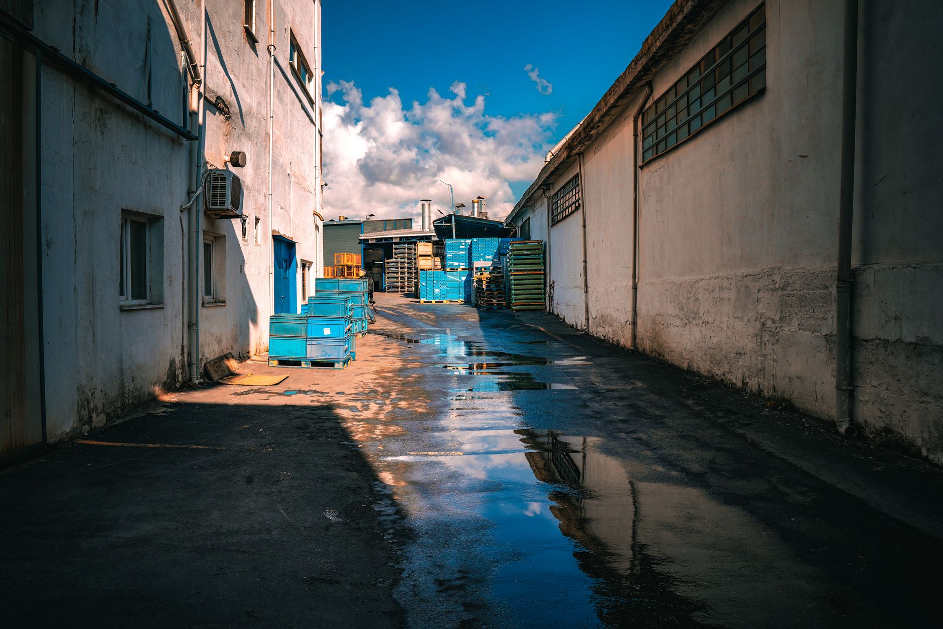 Rainwater puddles in a narrow alley between buildings