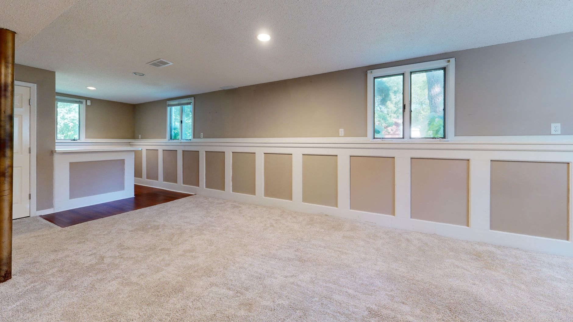 A finished basement room with windows