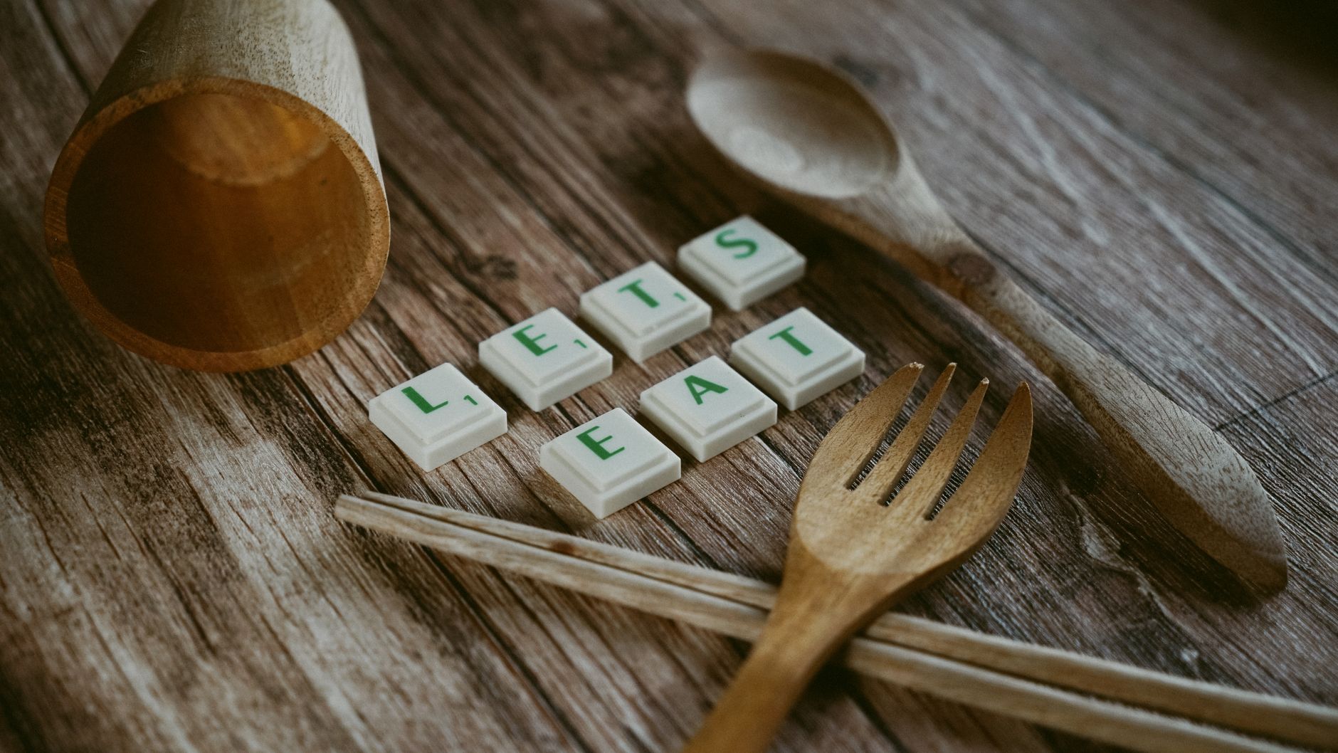 Wooden utensils and letter tiles on a table