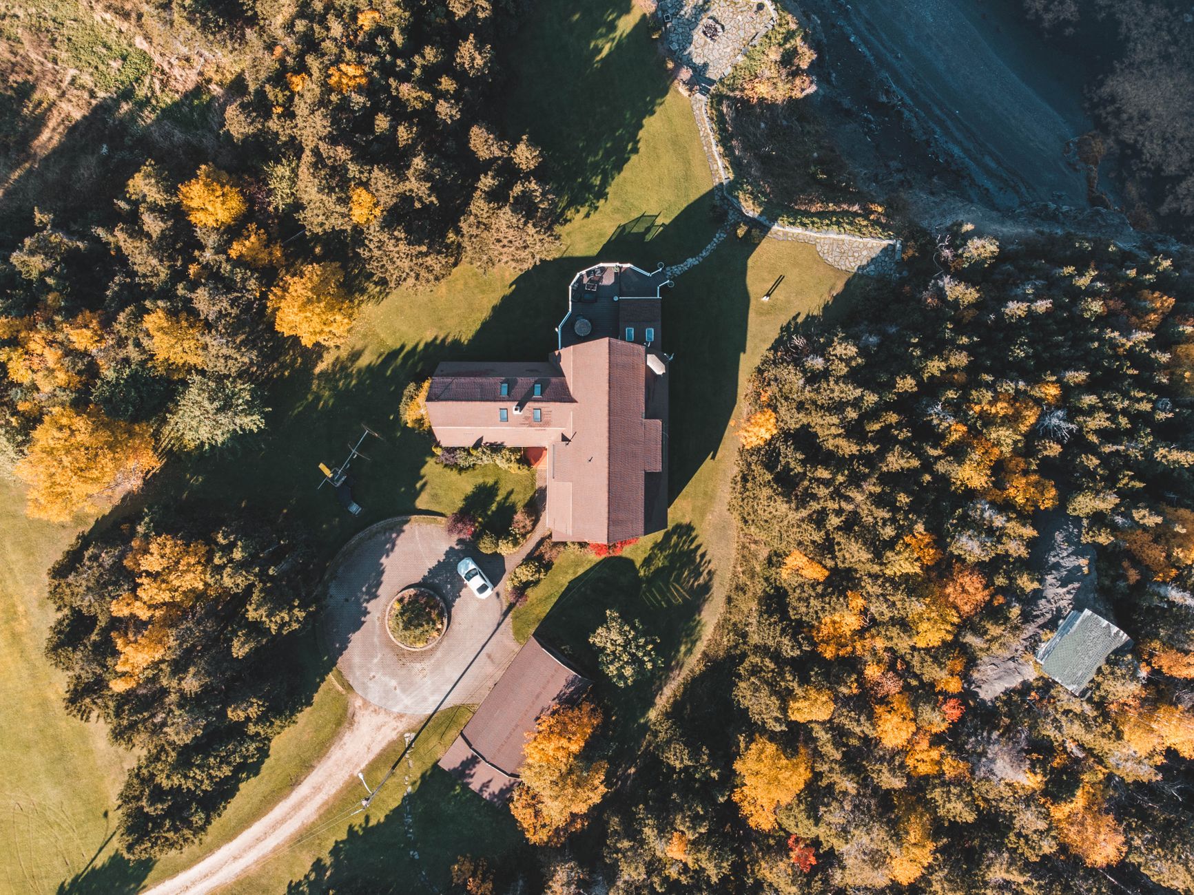 Aerial view of a rural home among autumn trees