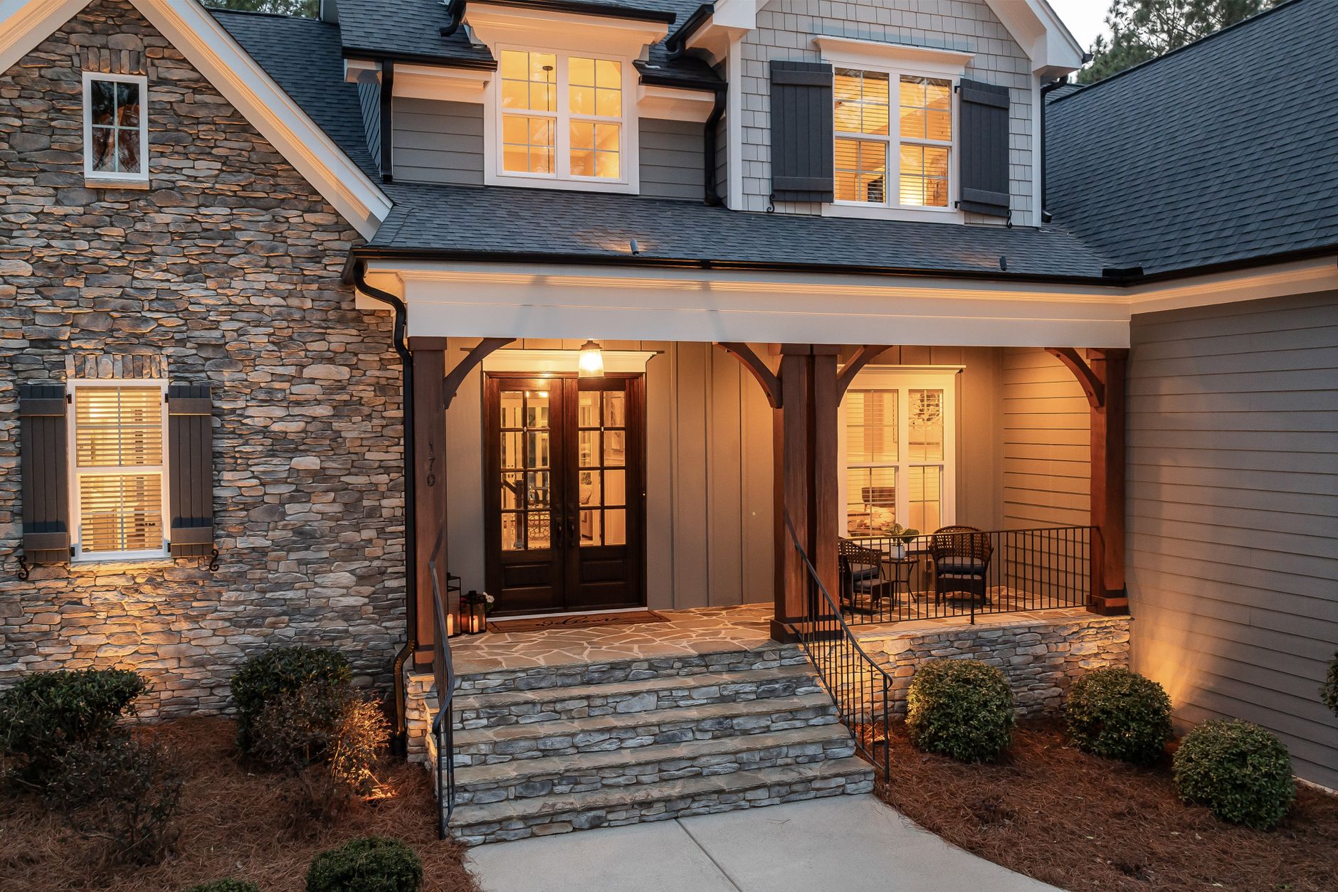 A stone house with a lit front porch