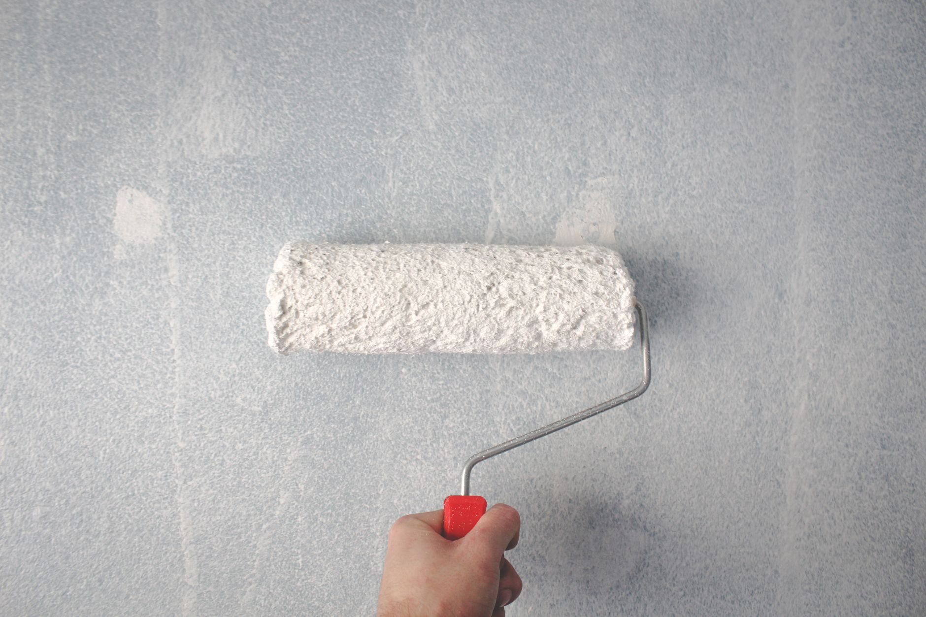 A paint roller applying color to an interior wall