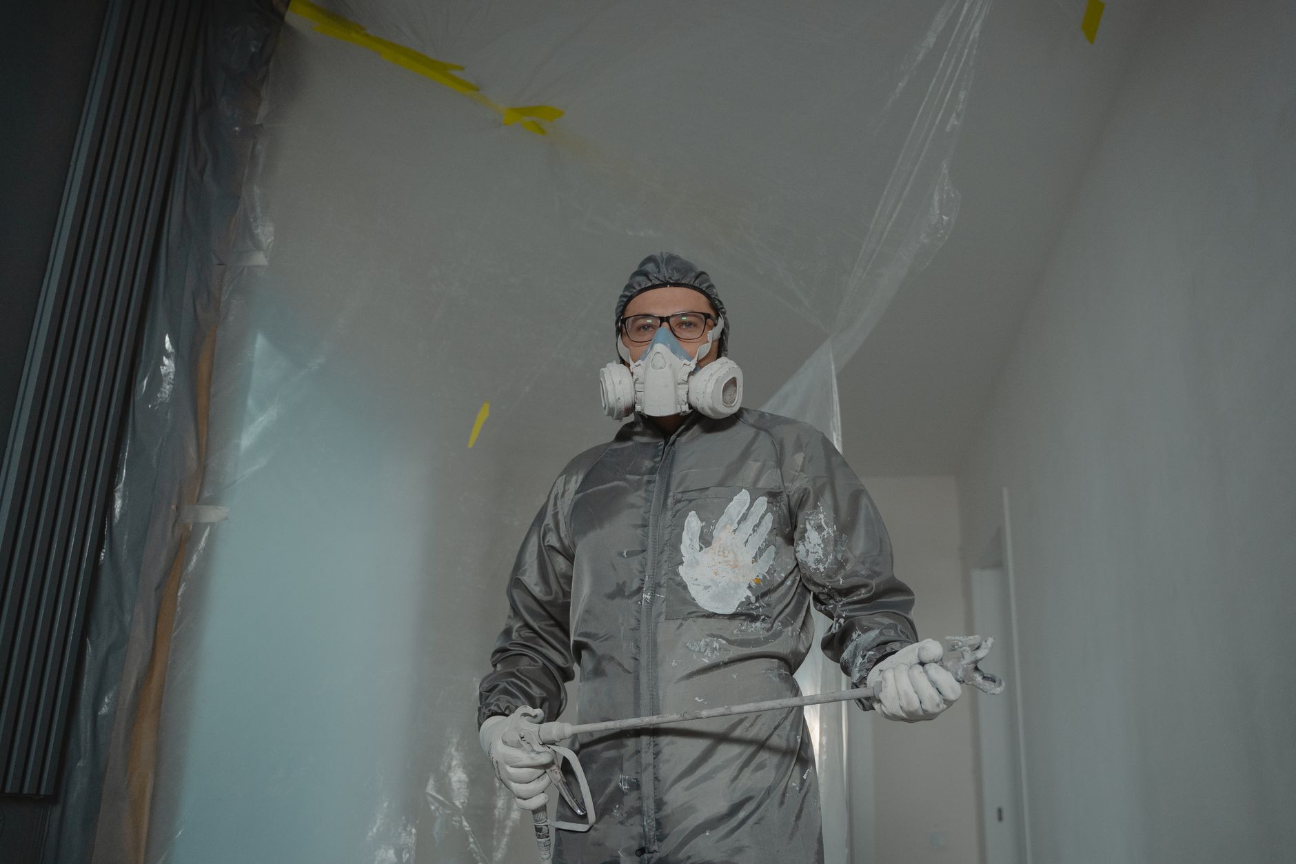 A worker in a respirator and protective suit