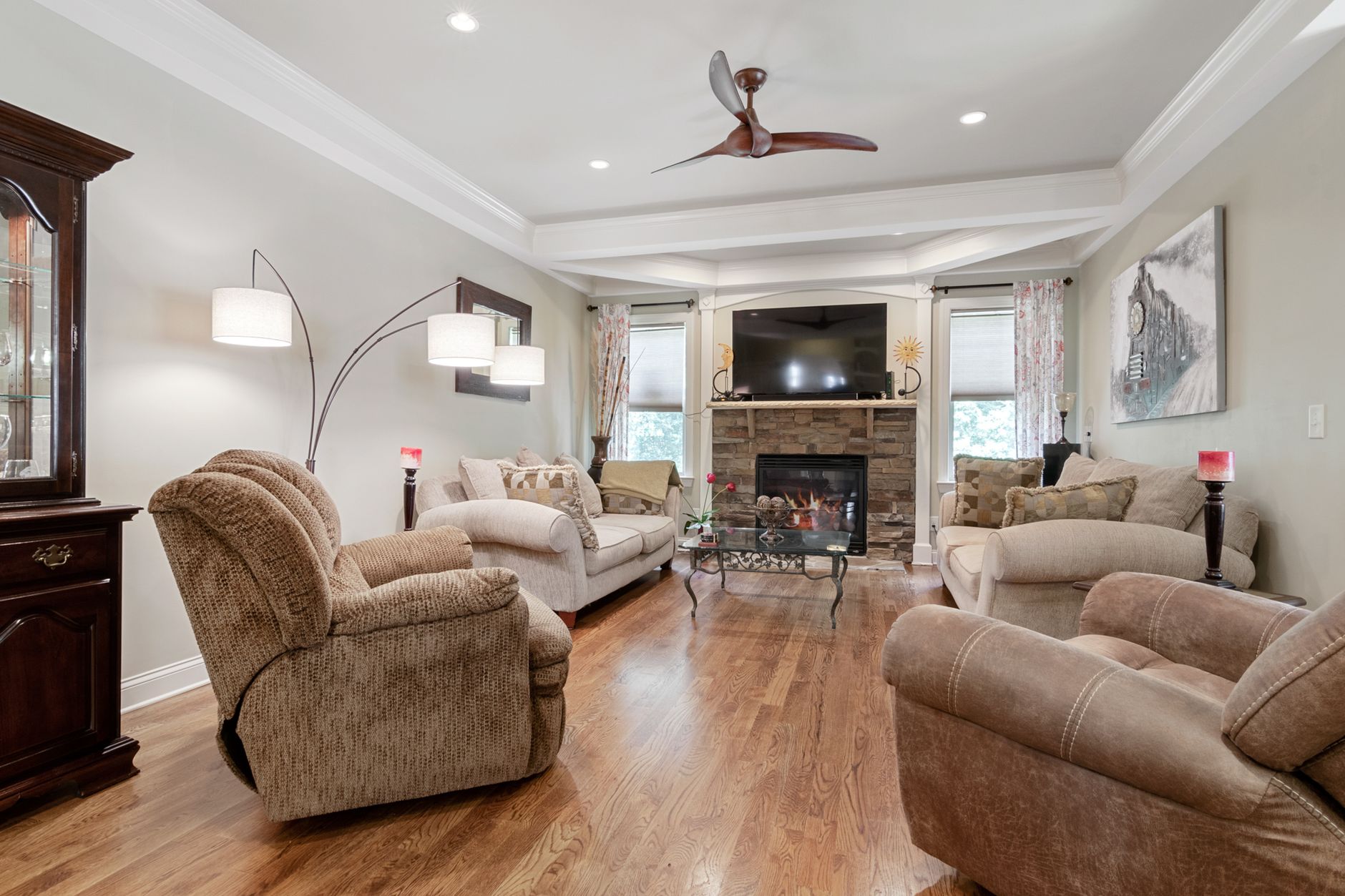 A living room with a ceiling fan and fireplace