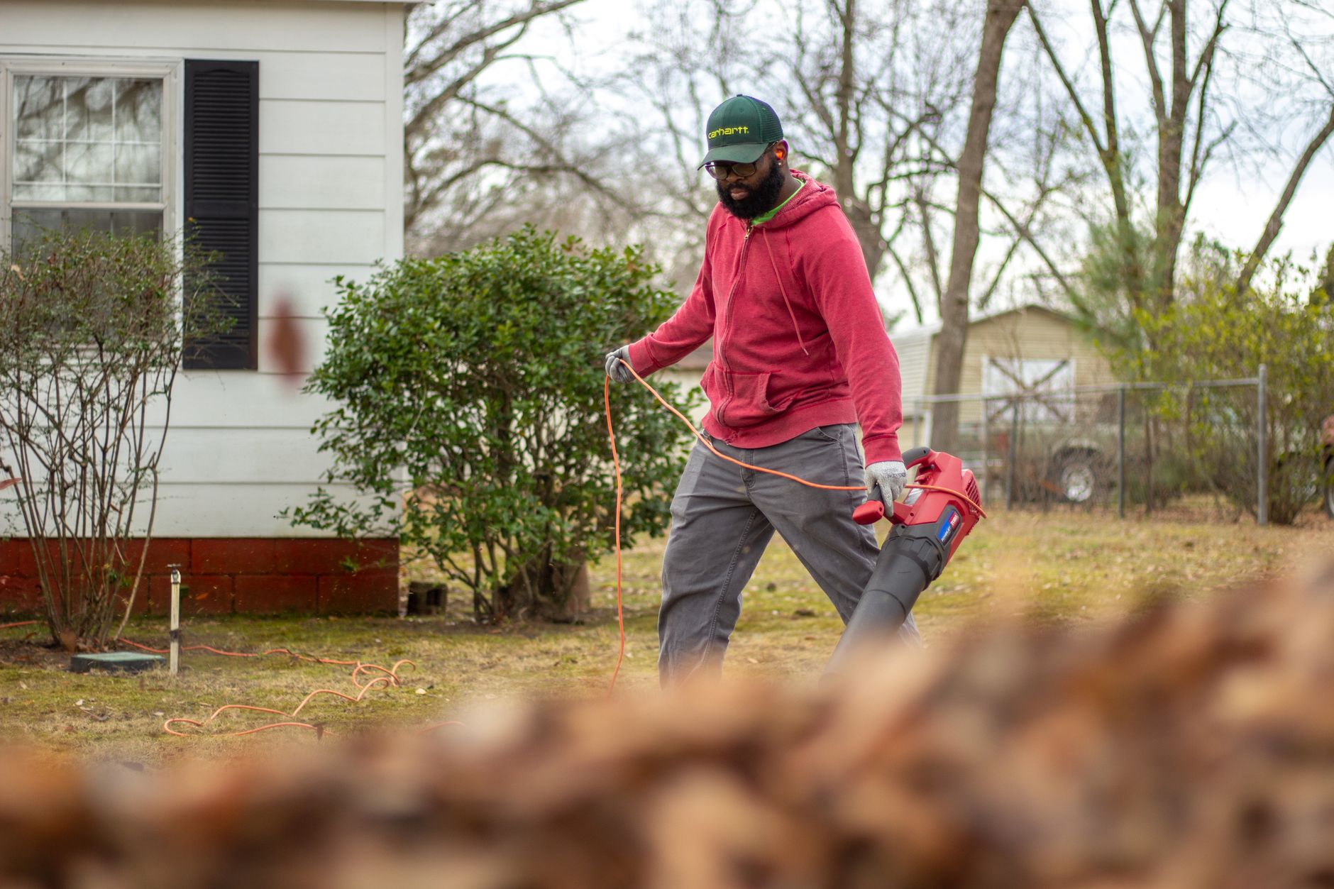A man using a leaf blower in a yard